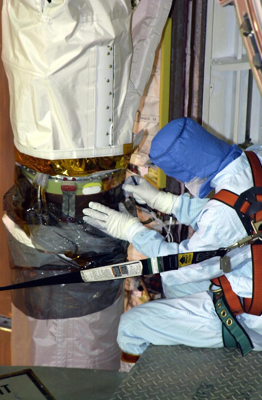 KENNEDY SPACE CENTER, FLA. --  One of a team of robotic experts looks at the site of the scrape on the surface of the  the robotic arm's honeycomb shell.  The scrape occurred while work platforms were being installed to gain access to repair the oxygen leak in Endeavour's mid-body.   The site will be cut out and ultrasound testing  will be done on the structure underneath. Launch of Endeavour on mission STS-113 has been postponed until no earlier than Nov. 22.  