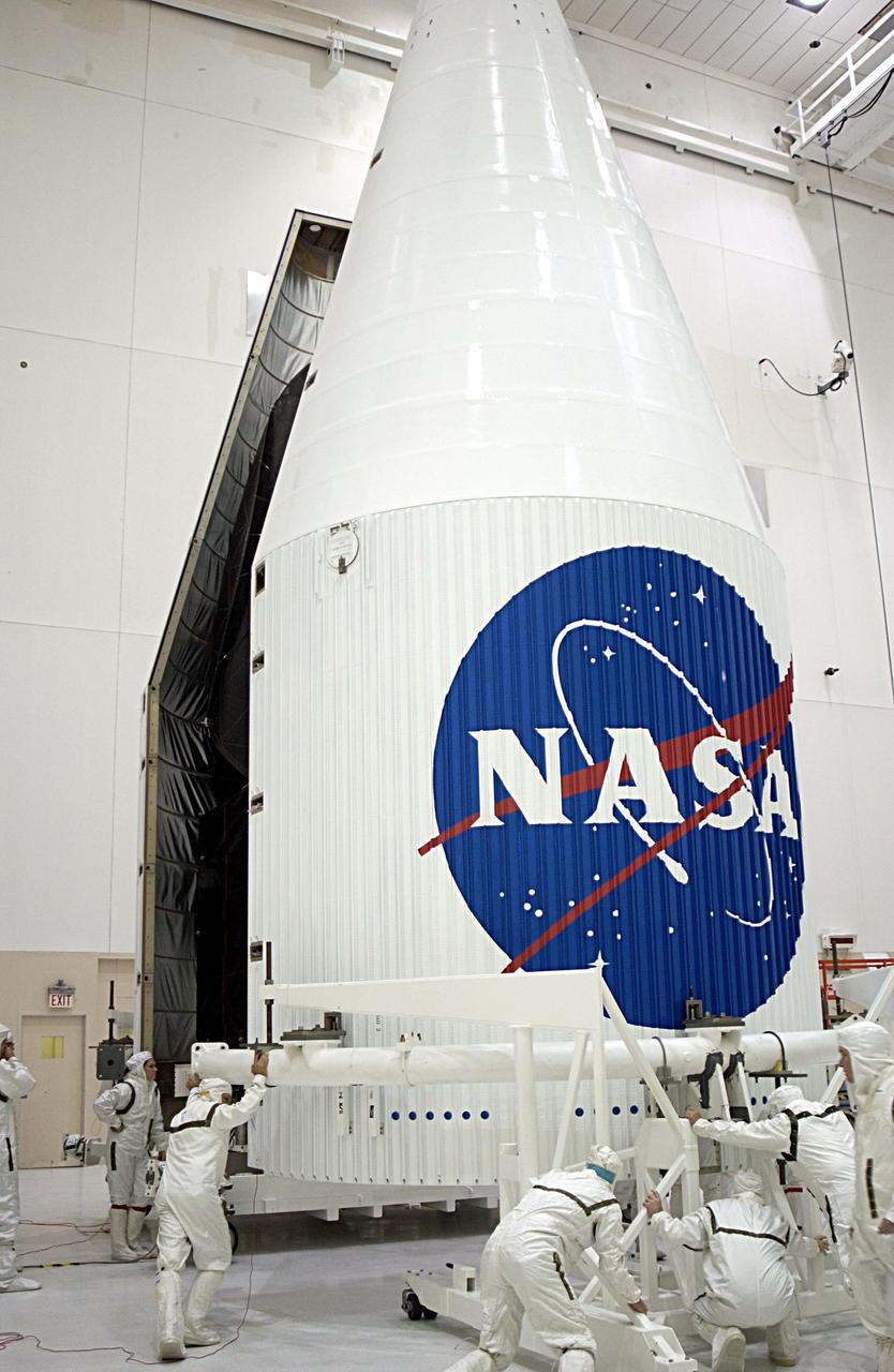 KENNEDY SPACE CENTER, FLA. --  Workers move the second half of the fairing around the TDRS-J satellite to complete encapsulation. The satellite is scheduled to be launched aboard a Lockheed Martin Atlas IIA-Centaur rocket from Launch Complex 36-A, Cape Canaveral Air Force Station, Fla., on Dec. 4.  The third in a series of telemetry satellites, TDRS-J will help replenish the current constellation of geosynchronous TDRS satellites. The TDRS System is the primary source of space-to-ground voice, data and telemetry for the Space Shuttle. It also provides communications with the International Space Station and scientific spacecraft in low-Earth orbit such as the Hubble Space Telescope. This new advanced series of satellites will extend the availability of TDRS communications services until about 2017.    