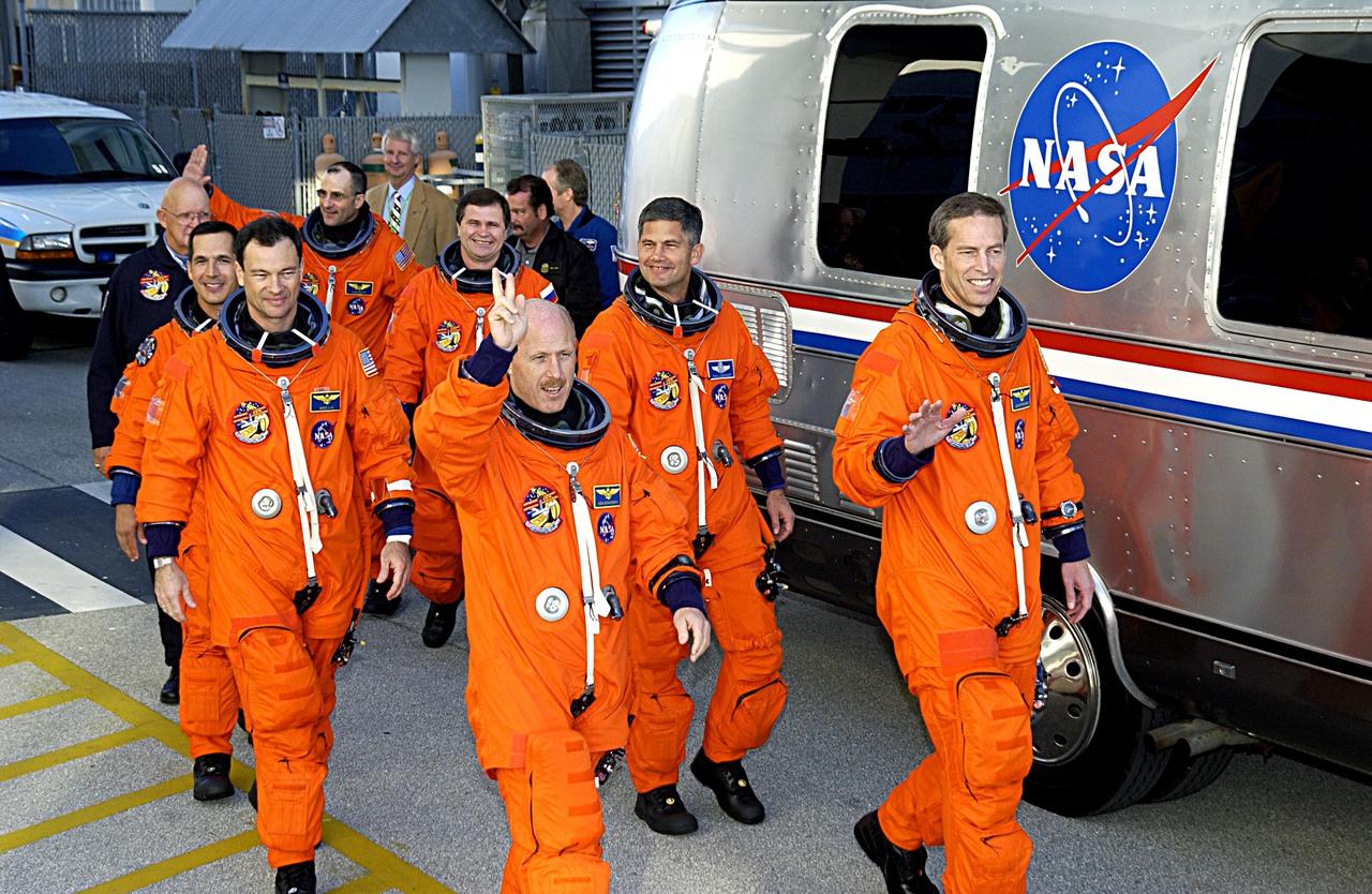 KENNEDY SPACE CENTER, FLA. - Waving at spectators, the STS-113 and Expedition 6 crews head for the Astrovan that will transport them to Launch Pad 39A and Space Shuttle Endeavour for a second launch attempt. The launch on Nov. 22 was scrubbed due to poor weather conditions at the Transoceanic Abort Landing sites.  In the foreground, from left, are Mission Specialists John Herrington and Michael Lopez-Alegria, and Expedition 6 Commander Ken Bowersox; in the background, from left, are  Expedition 6 flight engineers Donald Pettit and Nikolai Budarin, Mission Pilot Paul Lockhart and Commander James Wetherbee. The launch will carry the Expedition 6 crew to the Station and return the Expedition 5 crew to Earth.  The major objective of the mission is delivery of the Port 1 (P1) Integrated Truss Assembly, which will be attached to the port side of the S0 truss.  Three spacewalks are planned to install and activate the truss and its associated equipment.  Launch of Space Shuttle Endeavour on mission STS-113 is now scheduled for Nov. 23 at 7:50 p.m. EST.        