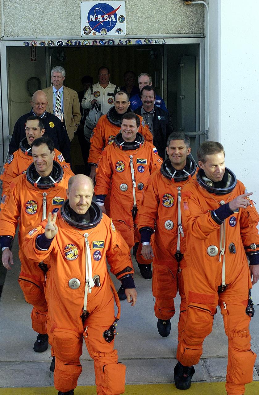 KENNEDY SPACE CENTER, FLA. -- The STS-113 and Expedition 6 crews leave the Operations and Checkout Building, heading for Launch Pad 39A and Space Shuttle Endeavour for a second launch attempt. The launch on Nov. 22 was scrubbed due to poor weather conditions at the Transoceanic Abort Landing sites.  In front, left to right, are Expedition 6 Commander Ken Bowersox and Mission Commander James Wetherbee; next row, Mission Specialist Michael Lopez-Alegria and Pilot Paul Lockhart; third row, Mission Specialist John Herrington and Expedition 6 flight engineer Nikolai Budarin; and finally, Expedition 6 flight engineer Donald Pettit. The launch will carry the Expedition 6 crew to the Station and return the Expedition 5 crew to Earth.  The major objective of the mission is delivery of the Port 1 (P1) Integrated Truss Assembly, which will be attached to the port side of the S0 truss.  Three spacewalks are planned to install and activate the truss and its associated equipment.  Launch of Space Shuttle Endeavour on mission STS-113 is now scheduled for Nov. 23 at 7:50 p.m. EST.  [Photo by Scott Andrews]    