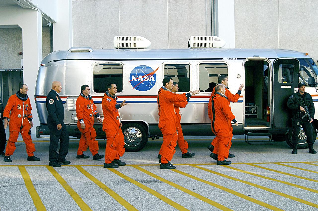 KENNEDY SPACE CENTER, FLA. -- The STS-113 and Expedition 6 crews head for the Astrovan that will transport them to Launch Pad 39A and Space Shuttle Endeavour for a second launch attempt. The launch on Nov. 22 was scrubbed due to poor weather conditions at the Transoceanic Abort Landing sites.  From left are Expedition 6 flight engineer Donald Pettit; a security guard; Expedition 6 flight engineer Nikolai Budarin; Mission Specialists John Herrington and Michael Lopez-Alegria, Pilot Paul Lockhart and Commander James Wetherbee (background); and Expedition 6 Commander Ken Bowersox. The launch will carry the Expedition 6 crew to the Station and return the Expedition 5 crew to Earth.  The major objective of the mission is delivery of the Port 1 (P1) Integrated Truss Assembly, which will be attached to the port side of the S0 truss.  Three spacewalks are planned to install and activate the truss and its associated equipment.  Launch of Space Shuttle Endeavour on mission STS-113 is now scheduled for Nov. 23 at 7:50 p.m. EST.  [Photo by Scott Andrews]        
