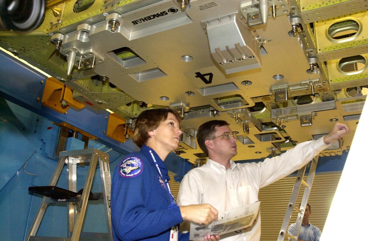 KENNEDY SPACE CENTER, FLA. - At the SPACEHAB facility in Cape Canaveral, STS-114 Commander Eileen Collins (left) and a technician participate in familiarization activities on the module that will fly on the STS-114 mission. STS-114 is a utilization and logistics flight that will carry Multi-Purpose Logistics Module Raffaello and the External Stowage Platform (ESP-2), as well as the Expedition 7 crew, to the International Space Station. Launch of STS-114 is currently targeted for March 1, 2003.