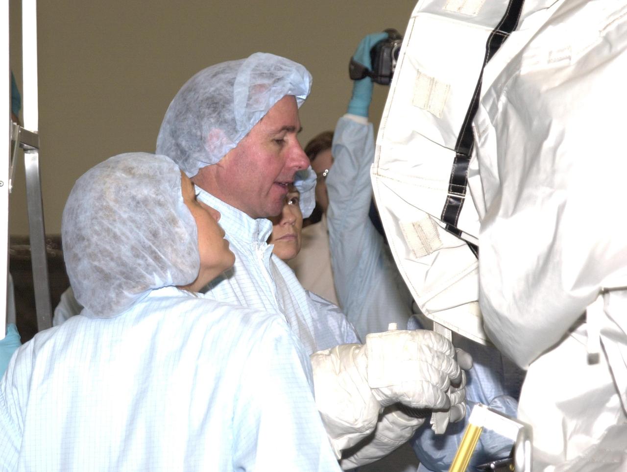 KENNEDY SPACE CENTER, FLA. - At the Space Station Processing Facility, STS-114 Mission Specialist Stephen Robinson (center), dressed in cleanroom attire, participates in familiarization activities on equipment that will fly on the STS-114 mission, as support personnel look on.  STS-114 is a utilization and logistics flight that will carry Multi-Purpose Logistics Module Raffaello and the External Stowage Platform (ESP-2), as well as the Expedition 7 crew, to the International Space Station. Launch of STS-114 is currently targeted for March 1, 2003.