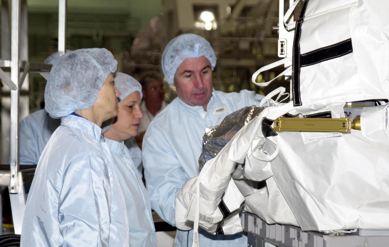 KENNEDY SPACE CENTER, FLA. - At the Space Station Processing Facility, STS-114 Commander Eileen Collins (left) and Mission Specialist Stephen Robinson (right), dressed in cleanroom attire, participate in familiarization activities on equipment that will fly on the STS-114 mission, as support personnel look on.  STS-114 is a utilization and logistics flight that will carry Multi-Purpose Logistics Module Raffaello and the External Stowage Platform (ESP-2), as well as the Expedition 7 crew, to the International Space Station. Launch of STS-114 is currently targeted for March 1, 2003.