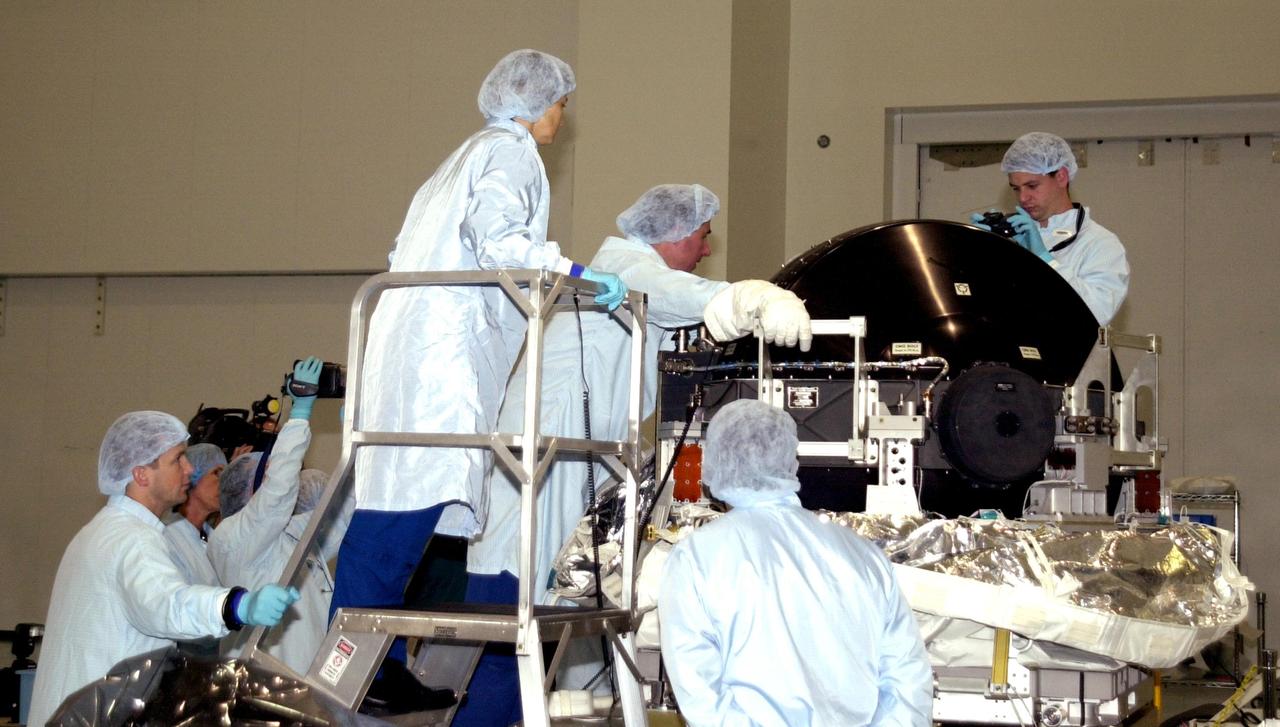 KENNEDY SPACE CENTER, FLA. - At the Space Station Processing Facility, STS-114 Commander Eileen Collins (left), Mission Specialist Stephen Robinson (center) and Pilot James Kelly (right), all dressed in cleanroom attire, participate in familiarization activities on equipment that will fly on the STS-114 mission, as support personnel look on from the floor below.  STS-114 is a utilization and logistics flight that will carry Multi-Purpose Logistics Module Raffaello and the External Stowage Platform (ESP-2), as well as the Expedition 7 crew, to the International Space Station. Launch of STS-114 is currently targeted for March 1, 2003.