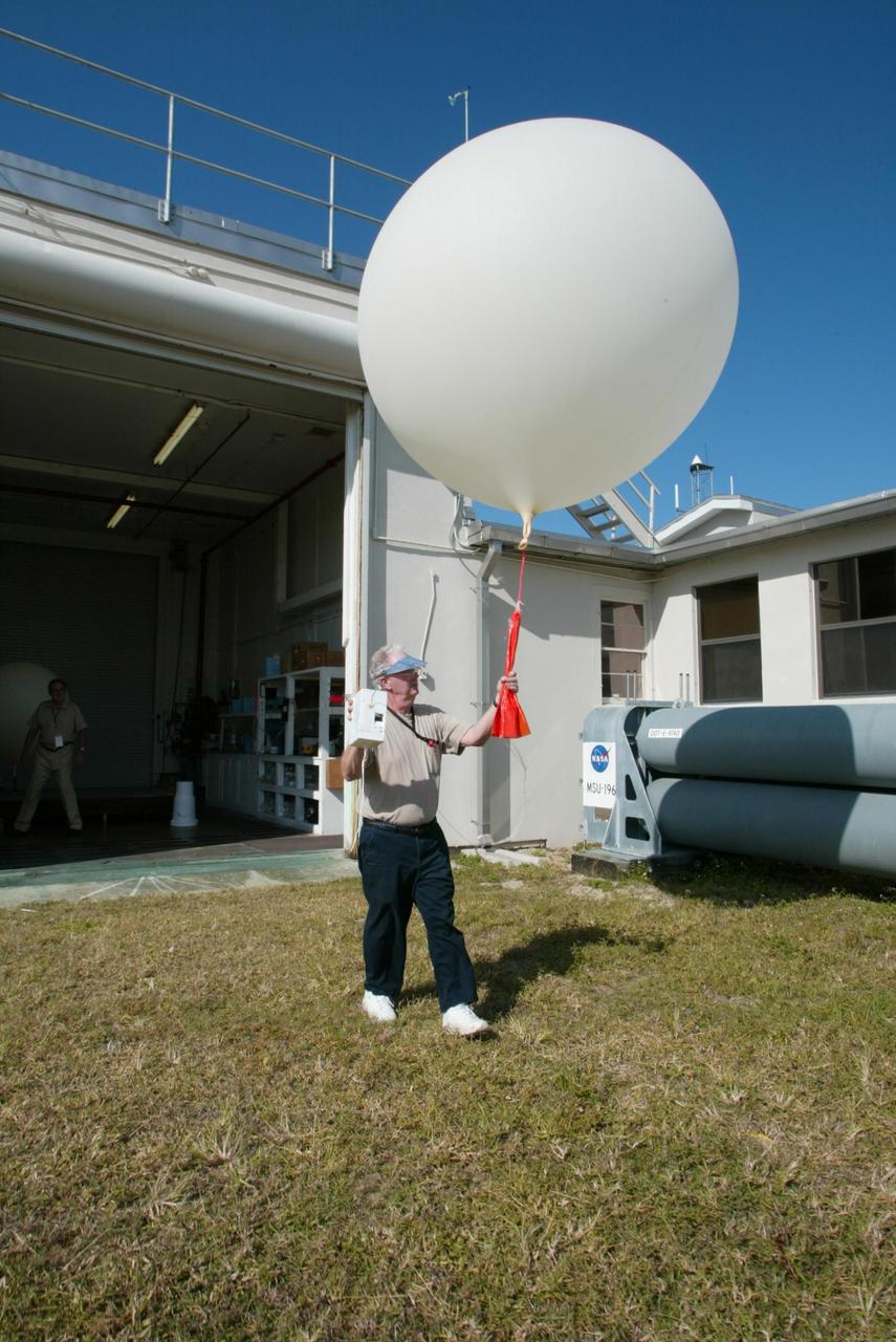 KENNEDY SPACE CENTER, FLA. - Stephen Ezell, meteorological systems operator at Weather Station A, Cape Canaveral Air Force Station, gets ready to release a weather balloon. Such balloons are released twice a day. The package in Ezell's hand is a radio sonde that collects temperature and humidity data as the balloon rises. The data is released to agencies nationwide, including the 45th Space Wing, which uses the data for its daily weather reports. The weather station provides additional data to NASA for launches -- releasing 12 balloons in eight hours prior to liftoff - and landings - releasing 5 balloons in six and a half hours before expected touchdown.
