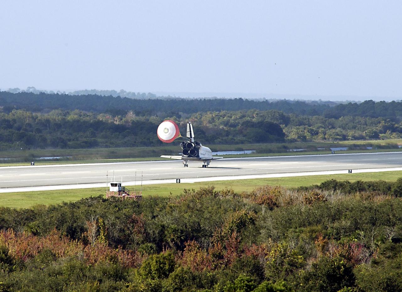 KENNEDY SPACE CENTER, FLA. - Space Shuttle Endeavour's drag chute deploys as the orbiter lands on runway 33 at the Shuttle Landing Facility after completing the 13-day, 18-hour, 48-minute, 5.74-million mile STS-113 mission to the International Space Station. Main gear touchdown was at 2:37:12 p.m. EST, nose gear touchdown was at 2:37:23 p.m., and wheel stop was at 2:38:25 p.m.  Poor weather conditions thwarted landing opportunities until a fourth day, the first time in Shuttle program history that a landing has been waved off for three consecutive days.  The vehicle carries the STS-113 crew, Commander James Wetherbee, Pilot Paul Lockhart and Mission Specialists Michael Lopez-Alegria and John Herrington, as well as the returning Expedition Five crew, Commander Valeri Korzun, ISS Science Officer Peggy Whitson and Flight Engineer Sergei Treschev. The installation of the P1 truss on the International Space Station was accomplished during the mission.