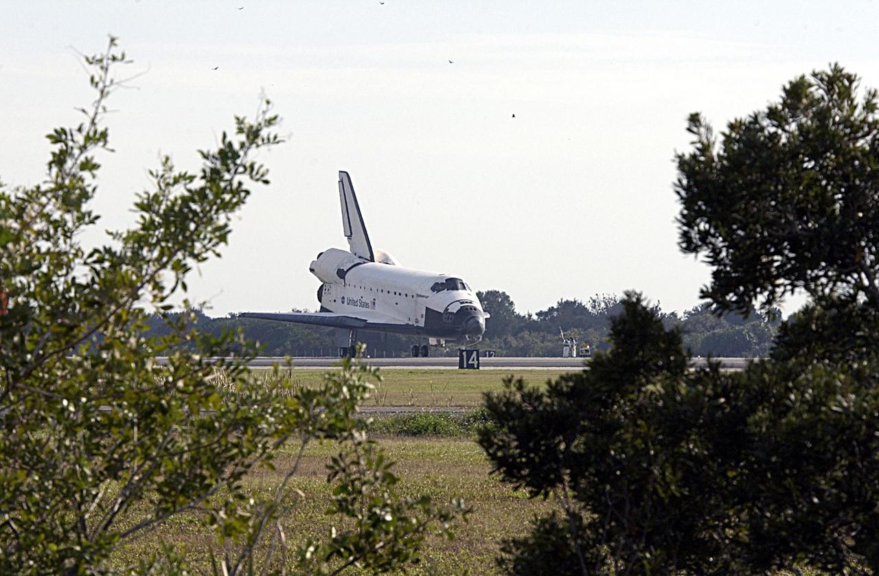 KENNEDY SPACE CENTER, FLA. - Seen through the lush Florida landscape, Space Shuttle Endeavour comes to a stop on runway 33 at the Shuttle Landing Facility after completing the 13-day, 18-hour, 48-minute, 5.74-million mile STS-113 mission to the International Space Station. Main gear touchdown was at 2:37:12 p.m. EST, nose gear touchdown was at 2:37:23 p.m., and wheel stop was at 2:38:25 p.m. Poor weather conditions thwarted landing opportunities until a fourth day, the first time in Shuttle program history that a landing has been waved off for three consecutive days. The vehicle carries the STS-113 crew, Commander James Wetherbee, Pilot Paul Lockhart and Mission Specialists Michael Lopez-Alegria and John Herrington, as well as the returning Expedition Five crew, Commander Valeri Korzun, ISS Science Officer Peggy Whitson and Flight Engineer Sergei Treschev. The installation of the P1 truss on the International Space Station was accomplished during the mission.