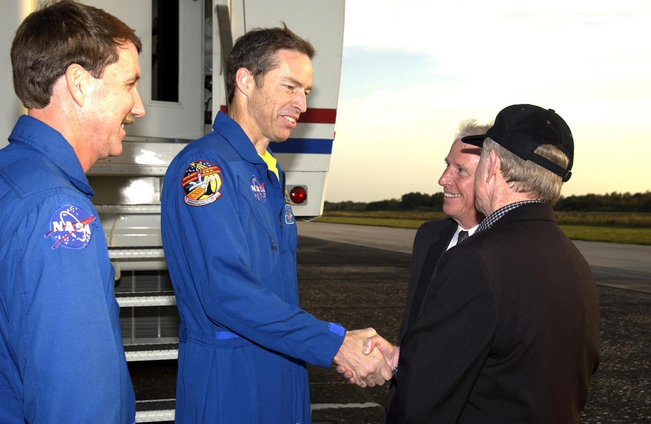 KENNEDY SPACE CENTER, FLA. - STS-113 Commander James Wetherbee shakes hands with KSC Director Roy D. Bridges Jr. following landing at the Shuttle Landing Facility.  From left are Kent Rominger, Deputy Director of Flight Crew Operations, Wetherbee, Dr. Daniel R. Mulville, NASA Associate Deputy Administrator, and Bridges. Commander Wetherbee earlier guided Space Shuttle Endeavour to a flawless touchdown on runway 33 at the Shuttle Landing Facility after completing the 13-day, 18-hour, 48-minute, 5.74-million mile STS-113 mission to the International Space Station. Main gear touchdown was at 2:37:12 p.m. EST, nose gear touchdown was at 2:37:23 p.m., and wheel stop was at 2:38:25 p.m.  Poor weather conditions thwarted landing opportunities until a fourth day, the first time in Shuttle program history that a landing has been waved off for three consecutive days.  The orbiter also carried the other members of the STS-113 crew, Pilot Paul Lockhart and Mission Specialists Michael Lopez-Alegria and John Herrington, as well as the returning Expedition Five crew, Commander Valeri Korzun, ISS Science Officer Peggy Whitson and Flight Engineer Sergei Treschev. The installation of the P1 truss on the International Space Station was accomplished during the mission.