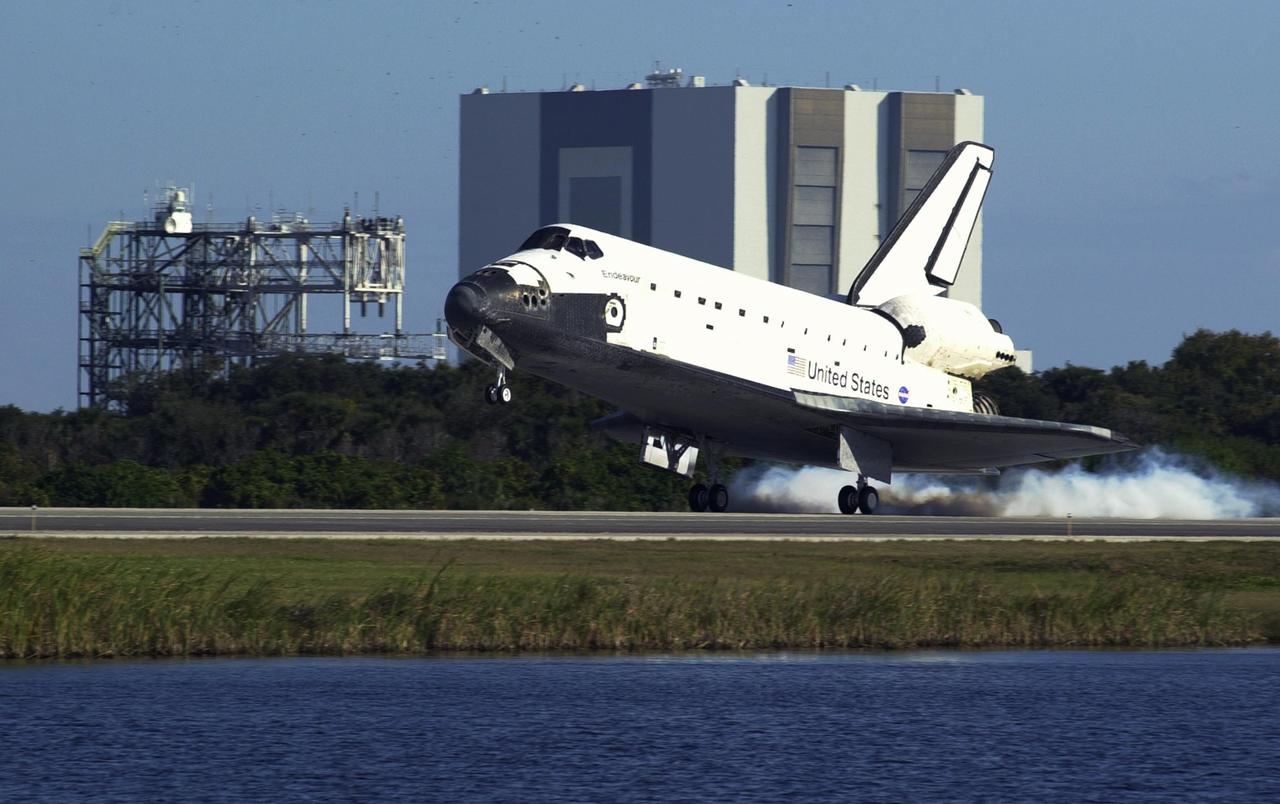KENNEDY SPACE CENTER, FLA. - Space Shuttle Endeavour touches down on runway 33 at the Shuttle Landing Facility (SLF) after completing the 13-day, 18-hour, 48-minute, 5.74-million mile STS-113 mission to the International Space Station. In the background are two well known landmarks at KSC: the SLF's Mate/Demate Device (left) and the 525-foot-tall Vehicle Assembly Building. Main gear touchdown was at 2:37:12 p.m. EST, nose gear touchdown was at 2:37:23 p.m., and wheel stop was at 2:38:25 p.m. Poor weather conditions thwarted landing opportunities until a fourth day, the first time in Shuttle program history that a landing has been waved off for three consecutive days. The vehicle carries the STS-113 crew, Commander James Wetherbee, Pilot Paul Lockhart and Mission Specialists Michael Lopez-Alegria and John Herrington, as well as the returning Expedition Five crew, Commander Valeri Korzun, ISS Science Officer Peggy Whitson and Flight Engineer Sergei Treschev. The installation of the P1 truss on the International Space Station was accomplished during the mission.