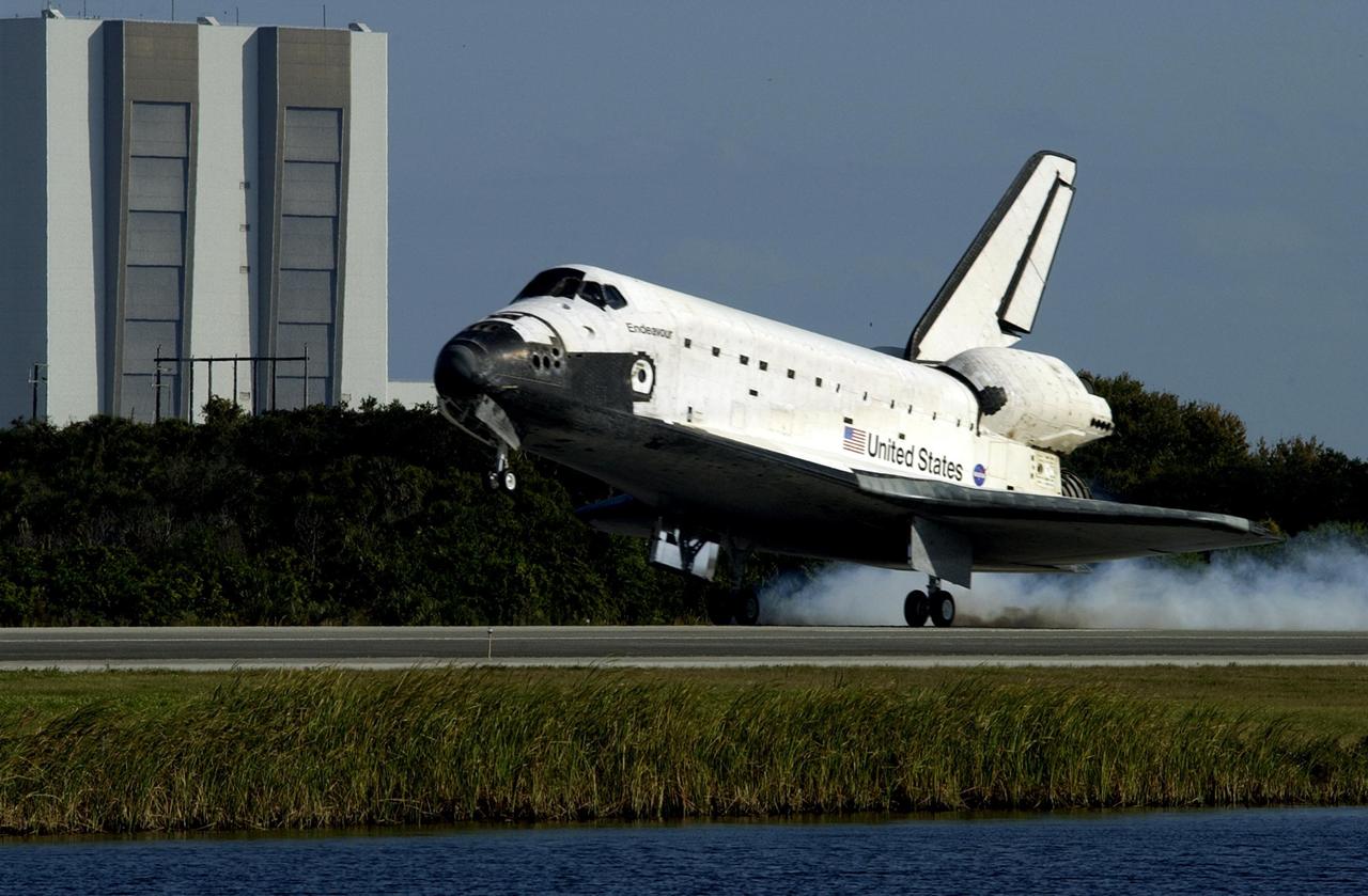KENNEDY SPACE CENTER, FLA. - Space Shuttle Endeavour touches down on runway 33 at the Shuttle Landing Facility (SLF) after completing the 13-day, 18-hour, 48-minute, 5.74-million mile STS-113 mission to the International Space Station. In the background is a well known KSC landmark: the 525-foot-tall Vehicle Assembly Building. Main gear touchdown was at 2:37:12 p.m. EST, nose gear touchdown was at 2:37:23 p.m., and wheel stop was at 2:38:25 p.m. Poor weather conditions thwarted landing opportunities until a fourth day, the first time in Shuttle program history that a landing has been waved off for three consecutive days. The vehicle carries the STS-113 crew, Commander James Wetherbee, Pilot Paul Lockhart and Mission Specialists Michael Lopez-Alegria and John Herrington, as well as the returning Expedition Five crew, Commander Valeri Korzun, ISS Science Officer Peggy Whitson and Flight Engineer Sergei Treschev. The installation of the P1 truss on the International Space Station was accomplished during the mission.