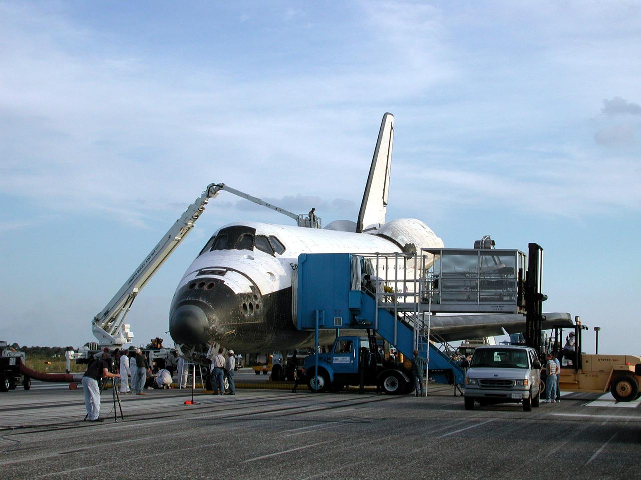 KENNEDY SPACE CENTER, FLA. -  Space Shuttle Endeavour is surrounded by vehicles from the landing convoy on runway 33 at the Shuttle Landing Facility at the conclusion of the 13-day, 18-hour, 48-minute, 5.74-million mile STS-113 mission to the International Space Station. The landing convoy's purpose is to  safe the vehicle and provide support for the disembarking crew and experiments.  Main gear touchdown was at 2:37:12 p.m. EST, nose gear touchdown was at 2:37:23 p.m., and wheel stop was at 2:38:25 p.m. Poor weather conditions thwarted landing opportunities until a fourth day, the first time in Shuttle program history that a landing has been waved off for three consecutive days. The vehicle carries the STS-113 crew, Commander James Wetherbee, Pilot Paul Lockhart and Mission Specialists Michael Lopez-Alegria and John Herrington, as well as the returning Expedition Five crew, Commander Valeri Korzun, ISS Science Officer Peggy Whitson and Flight Engineer Sergei Treschev. The installation of the P1 truss on the International Space Station was accomplished during the mission.