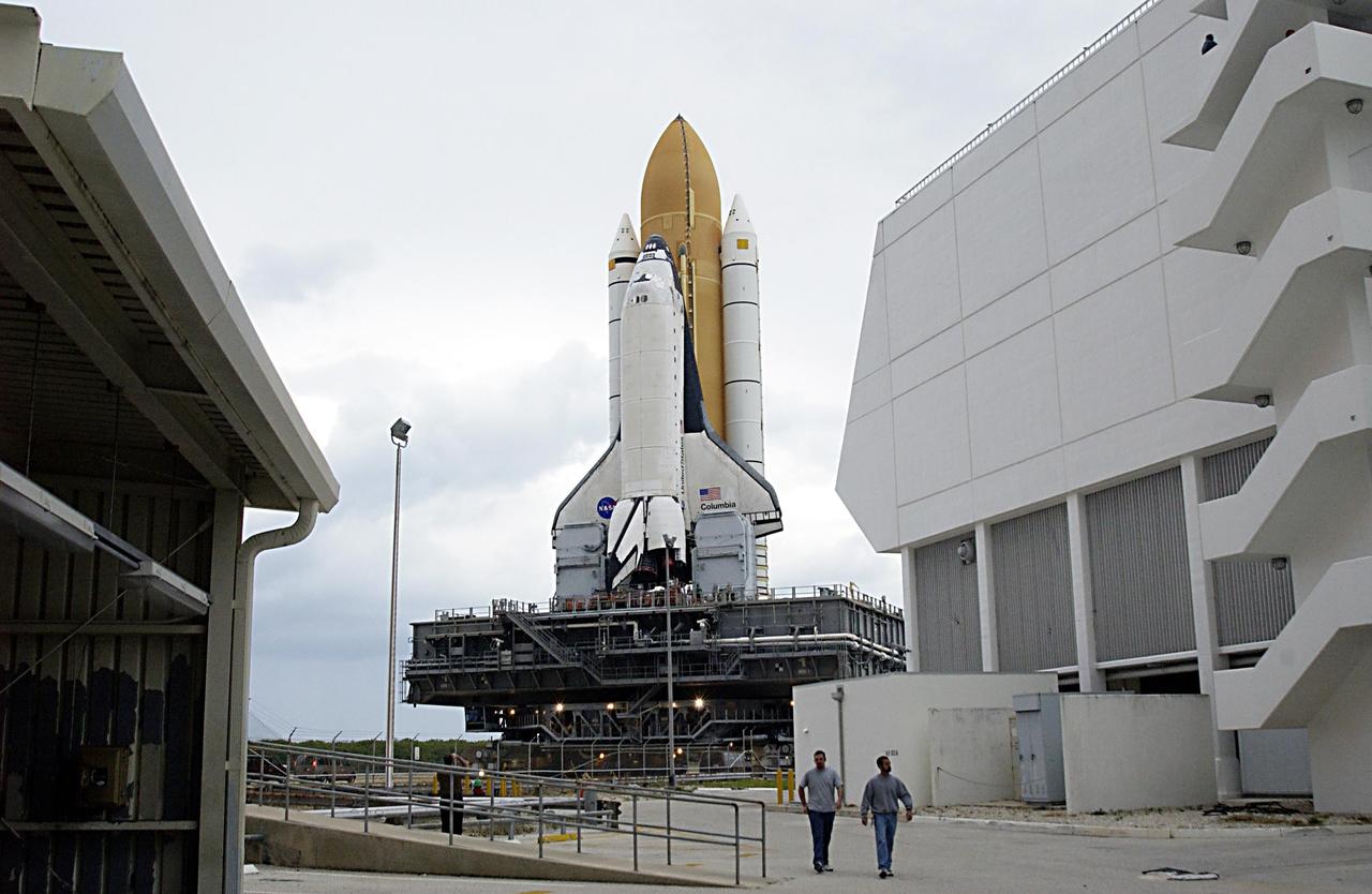 KENNEDY SPACE CENTER, FLA. -- Space Shuttle Columbia, sitting atop the Mobile Launcher Platform, which in turn is carried by the crawler-transporter underneath, makes the journey past the Launch Control Center on its way to Launch Pad 39A. The STS-107 research mission comprises experiments ranging from material sciences to life sciences (many rats), plus the Fast Reaction Experiments Enabling Science, Technology, Applications and Research (FREESTAR) that incorporates eight high priority secondary attached shuttle experiments. Mission STS-107 is scheduled to launch Jan. 16, 2003.