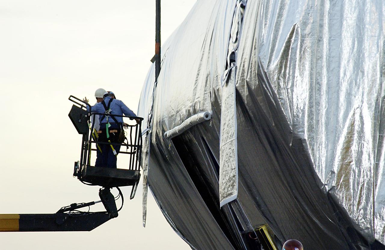 KENNEDY SPACE CENTER, FLA. -- KSC technicians supervise the offloading of the Integrated Equipment Assembly (IEA), one of two major components of the Starboard 6 (S6) truss segment for the International Space Station (ISS), onto a cargo transporter following its arrival at the Shuttle Landing Facility. The IEA will be joined to its companion piece, the Long Spacer, before launch early in 2004.  The S6 truss segment will be the 11th and final piece of the Station's Integrated Truss Structure and will support the fourth and final set of solar arrays, batteries, and electronics. 