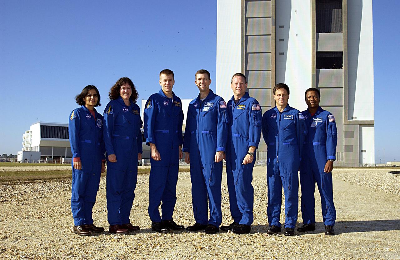 KENNEDY SPACE CENTER, FLA. --  The STS-107 crew poses for a group portrait with the Vehicle Assembly Building in the background.  They are at KSC to take part in Terminal Countdown Demonstration Test activities, a standard part of launch preparations. From left to right are Mission Specialists Kalpana Chawla and Laurel Clark, Pilot William "Willie" McCool, Commander Rick Husband, Mission Specialist David Brown, Payload Specialist Ilan Ramon (the first Israeli astronaut), and Payload Commander Michael Anderson. STS-107 is a mission devoted to research and will include more than 80 experiments that will study Earth and space science, advanced technology development, and astronaut health and safety.  Launch is targeted for Jan. 16, 2003, between 10 a.m. and 2 p.m. EST.