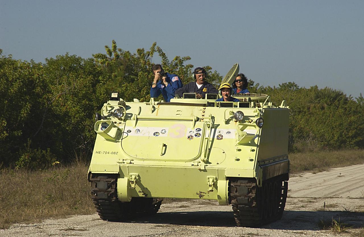 KENNEDY SPACE CENTER, FLA. --  STS-107 Mission Specialist Laurel Clark (in yellow cap) is instructed on the operation of an M113 armored personnel carrier during Terminal Countdown Demonstration Test activities, a standard part of launch preparations.  STS-107 is a mission devoted to research and will include more than 80 experiments that will study Earth and space science, advanced technology development, and astronaut health and safety.  Launch is planned for Jan. 16, 2003, between 10 a.m. and 2 p.m. EST aboard Space Shuttle Columbia.