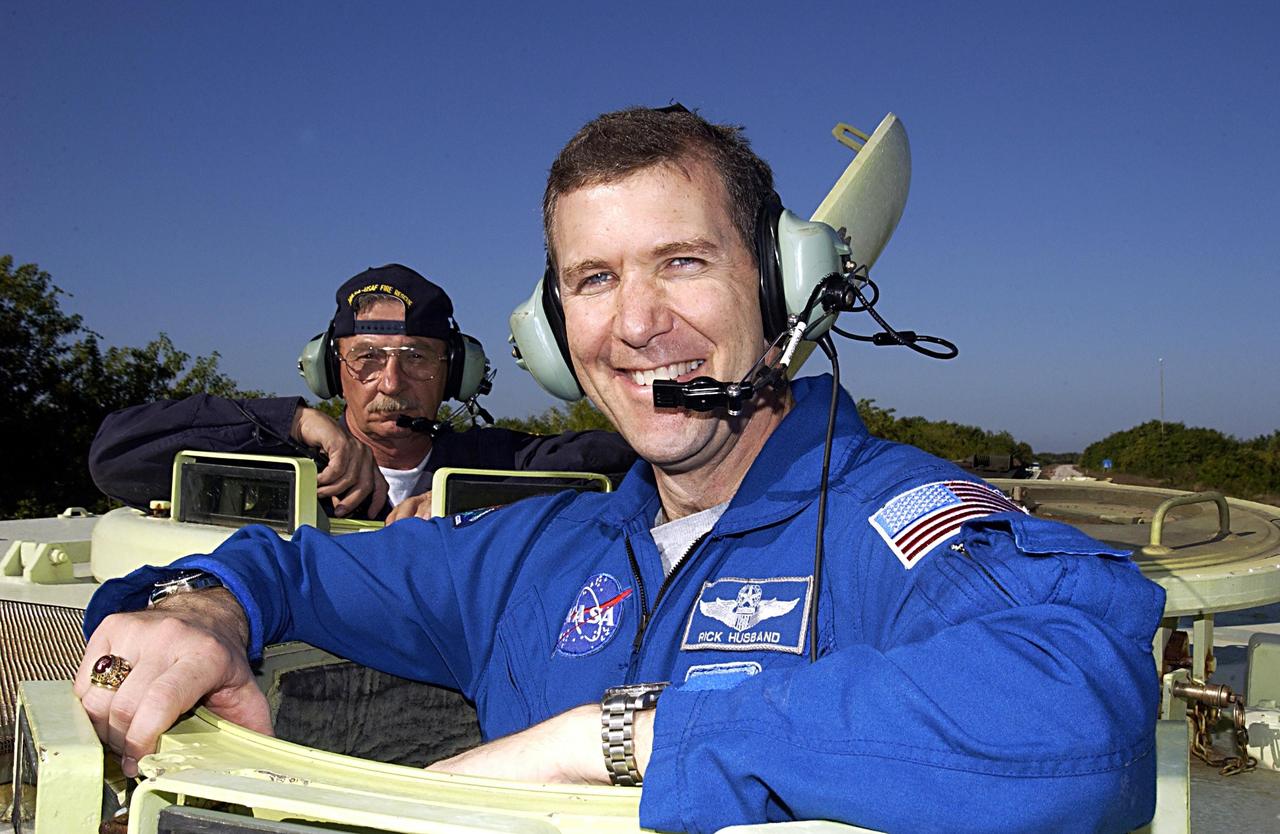 KENNEDY SPACE CENTER, FLA. --  STS-107 Commander Rick Husband takes a break during training on the operation of an M113 armored personnel carrier during Terminal Countdown Demonstration Test activities, a standard part of launch preparations. Instructor George Hoggard looks on over Husband's shoulder.  STS-107 is a mission devoted to research and will include more than 80 experiments that will study Earth and space science, advanced technology development, and astronaut health and safety. Launch is planned for Jan. 16, 2003, between 10 a.m. and 2 p.m. EST aboard Space Shuttle Columbia.