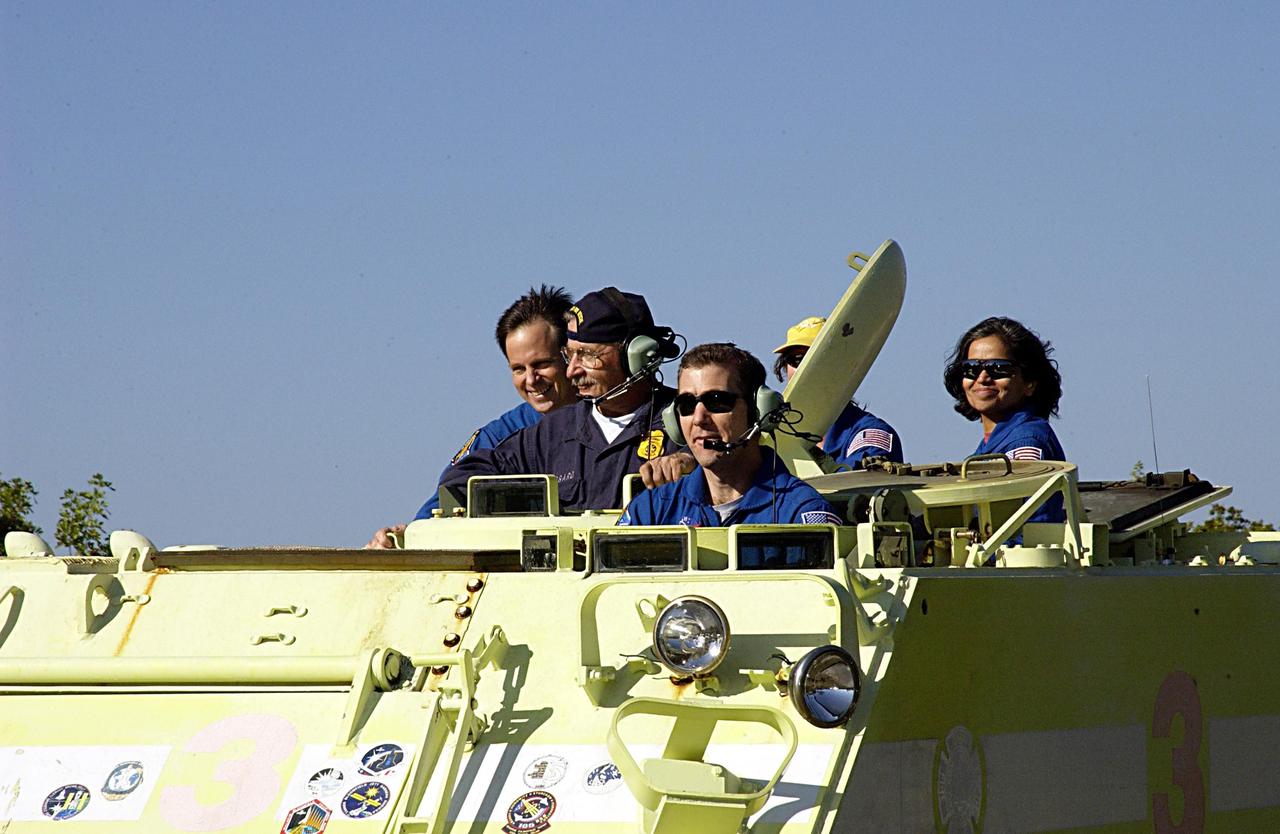 KENNEDY SPACE CENTER, FLA. --  STS-107 Commander Rick Husband operates an M113 armored personnel carrier during Terminal Countdown Demonstration Test activities, a standard part of launch preparations. From left, Payload Specialist Ilan Ramon, the first Israeli astronaut, Instructor George Hoggard, and Mission Specialists Laurel Clark (face obscured) and Kalpana Chawla enjoy the ride in the background.  STS-107 is a mission devoted to research and will include more than 80 experiments that will study Earth and space science, advanced technology development, and astronaut health and safety. Launch is planned for Jan. 16, 2003, between 10 a.m. and 2 p.m. EST aboard Space Shuttle Columbia.