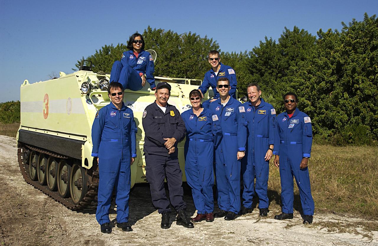KENNEDY SPACE CENTER, FLA. --  -- The STS-107 crew poses for a group portrait with their instructor beside an M113 armored personnel carrier. The crew is participating in Terminal Countdown Demonstration Test activities, a standard part of launch preparations.  In the front, from left, are Payload Specialist Ilan Ramon (the first Israeli astronaut), Instructor George Hoggard, Mission Specialist Laurel Clark, Commander Rick Husband, Mission Specialist David Brown, and Payload Commander Michael Anderson.  In the back, from left, are Mission Specialist Kalpana Chawla and Pilot William "Willie" McCool.  STS-107 is a mission devoted to research and will include more than 80 experiments that will study Earth and space science, advanced technology development, and astronaut health and safety. Launch is planned for Jan. 16, 2003, between 10 a.m. and 2 p.m. EST aboard Space Shuttle Columbia.