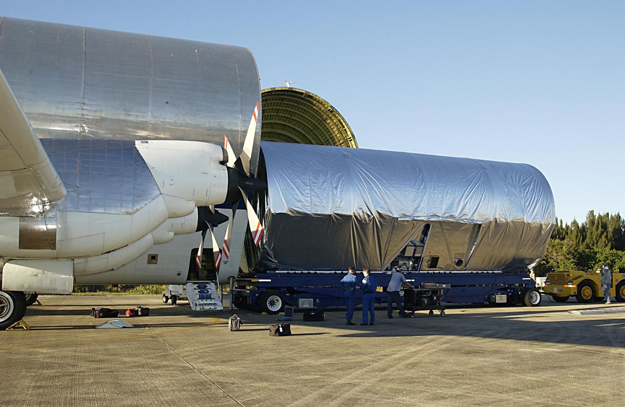 KENNEDY SPACE CENTER, FLA. -- The Long Spacer (LS), the second and final piece of the Starboard 6 (S6) Integrated Truss Segment, rolls out of NASA's Super Guppy cargo airplane onto a transporter. The LS will be moved to the Space Station Processing Facility for inspections and verification tests. Eventually the LS will be integrated with the S6 Integrated Equipment Assembly already at KSC and will fly as one segment to the International Space Station on Space Shuttle mission STS-119 in early 2004. Together the segment pieces weigh 26,000 pounds and measure 45 feet long. .
