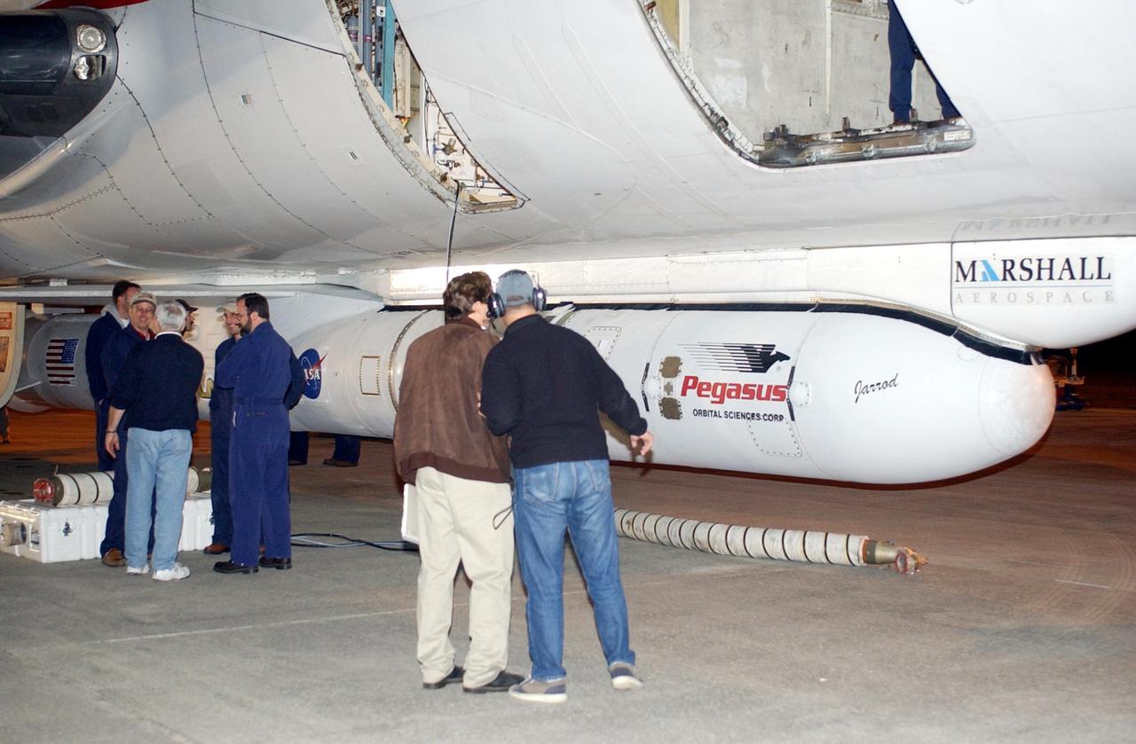 KENNEDY SPACE CENTER, FLA. -- Workers at the Cape Canaveral Air Force Station Skid Strip look over the Pegasus XL Expendable Launch Vehicle attached underneath the Orbital Sciences L-1011 aircraft. The Pegasus will be transported to the Multi-Payload Processing Facility for testing and verification. The Pegasus will undergo three flight simulations prior to its scheduled launch in late January 2003. The Pegasus XL will carry NASA's Solar Radiation and Climate Experiment (SORCE) into orbit. Built by Orbital Sciences Space Systems Group, SORCE will study and measure solar irradiance as a source of energy in the Earth's atmosphere. .