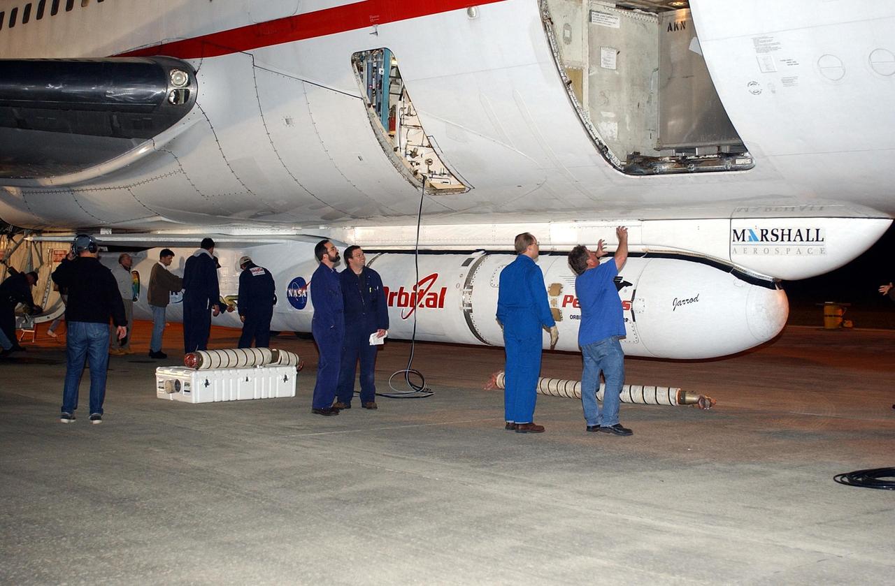 KENNEDY SPACE CENTER, FLA. -- Workers at the Cape Canaveral Air Force Station Skid Strip get ready to remove the Pegasus XL Expendable Launch Vehicle attached underneath the Orbital Sciences L-1011 aircraft. The Pegasus will be transported to the Multi-Payload Processing Facility for testing and verification. The Pegasus will undergo three flight simulations prior to its scheduled launch in late January 2003. The Pegasus XL will carry NASA's Solar Radiation and Climate Experiment (SORCE) into orbit. Built by Orbital Sciences Space Systems Group, SORCE will study and measure solar irradiance as a source of energy in the Earth's atmosphere. .