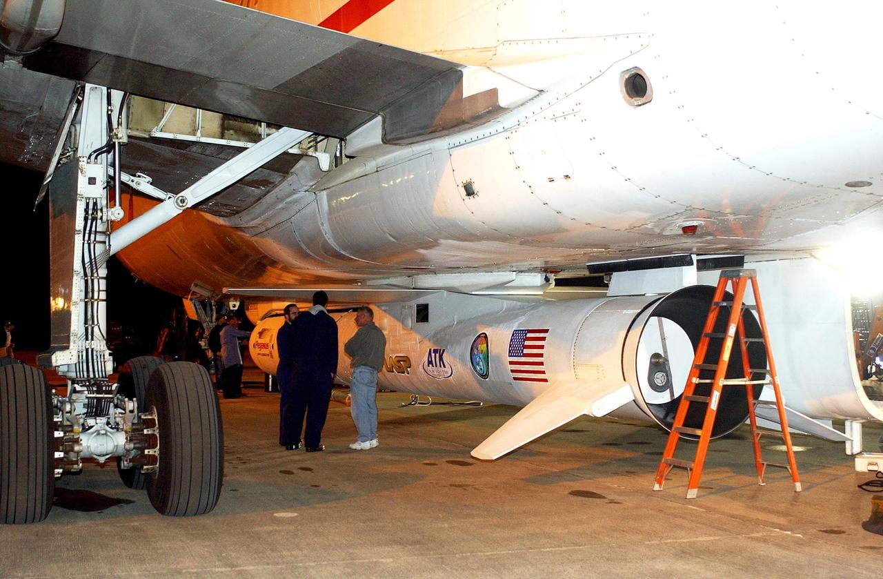 KENNEDY SPACE CENTER, FLA. -- Workers at the Cape Canaveral Air Force Station Skid Strip stand next to the Pegasus XL Expendable Launch Vehicle underneath the Orbital Sciences L-1011 aircraft. The Pegasus will be transported to the Multi-Payload Processing Facility for testing and verification. The Pegasus will undergo three flight simulations prior to its scheduled launch in late January 2003. The Pegasus XL will carry NASA's Solar Radiation and Climate Experiment (SORCE) into orbit. Built by Orbital Sciences Space Systems Group, SORCE will study and measure solar irradiance as a source of energy in the Earth's atmosphere. .