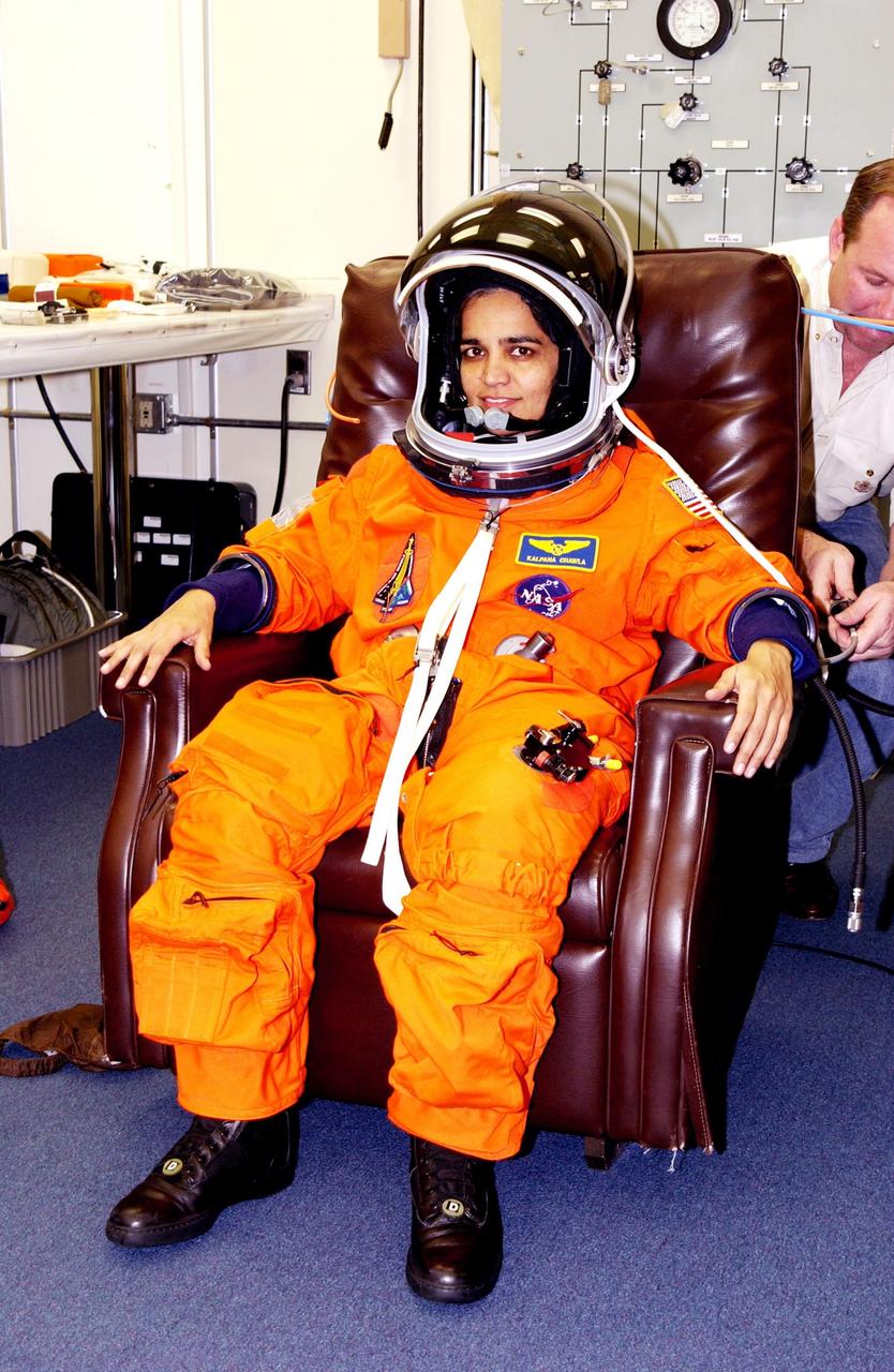 KENNEDY SPACE CENTER, FLA. -- STS-107 Mission Specialist Kalpana Chawla is helped suiting up for Terminal Countdown Demonstration Test activities, which include a simulated launch countdown at the pad. STS-107 is a mission devoted to research and will include more than 80 experiments that will study Earth and space science, advanced technology development, and astronaut health and safety. Launch is planned for Jan. 16, 2003, between 10 a.m. and 2 p.m. EST aboard Space Shuttle Columbia. .