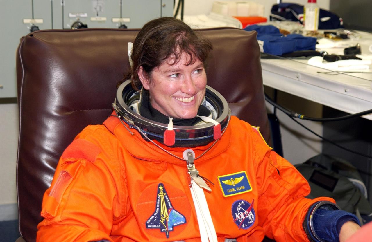 KENNEDY SPACE CENTER, FLA. - STS-107 Mission Specialist Laurel Clark happily submits to suit check prior to Terminal Countdown Demonstration Test activities, which include a simulated launch countdown at the pad. STS-107 is a mission devoted to research and will include more than 80 experiments that will study Earth and space science, advanced technology development, and astronaut health and safety. Launch is planned for Jan. 16, 2003, between 10 a.m. and 2 p.m. EST aboard Space Shuttle Columbia. .