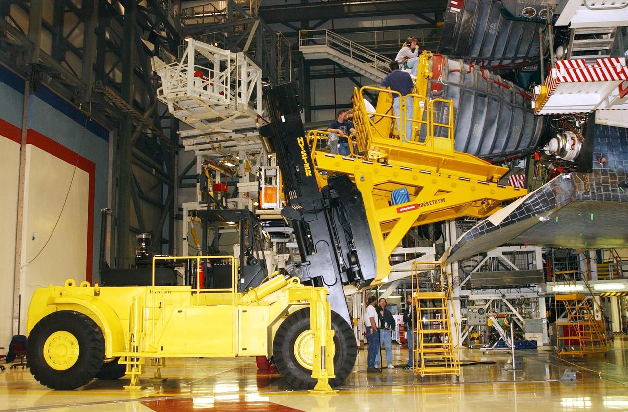 KENNEDY SPACE CENTER, FLA. - In the Orbiter Processing Facility, workers use a new engine hyster, built by Rocketdyne, to remove an engine on an orbiter. .