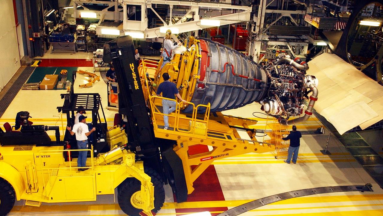 KENNEDY SPACE CENTER, FLA. -- In the Orbiter Processing Facility, workers use a new engine hyster, built by Rocketdyne, to remove an engine on an orbiter. .