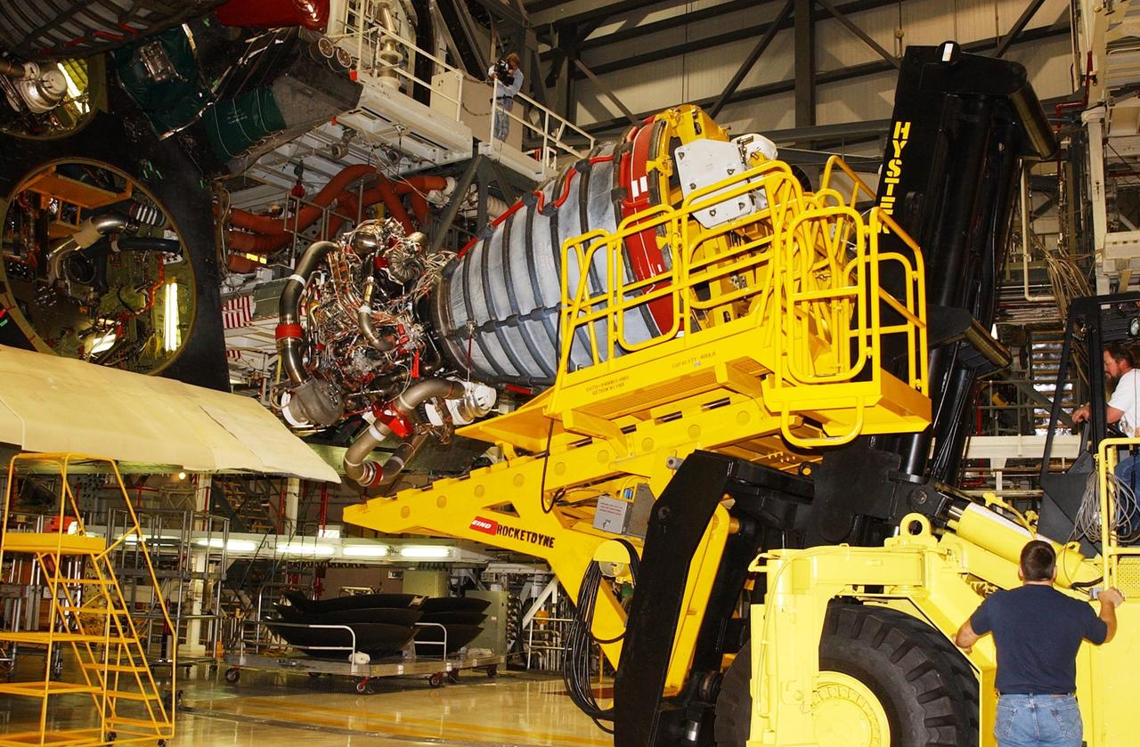 KENNEDY SPACE CENTER, FLA. -- In the Orbiter Processing Facility, an orbiter main engine is lifted by a new engine hyster, built by Rocketdyne, that is used to remove it from the orbiter.        .  