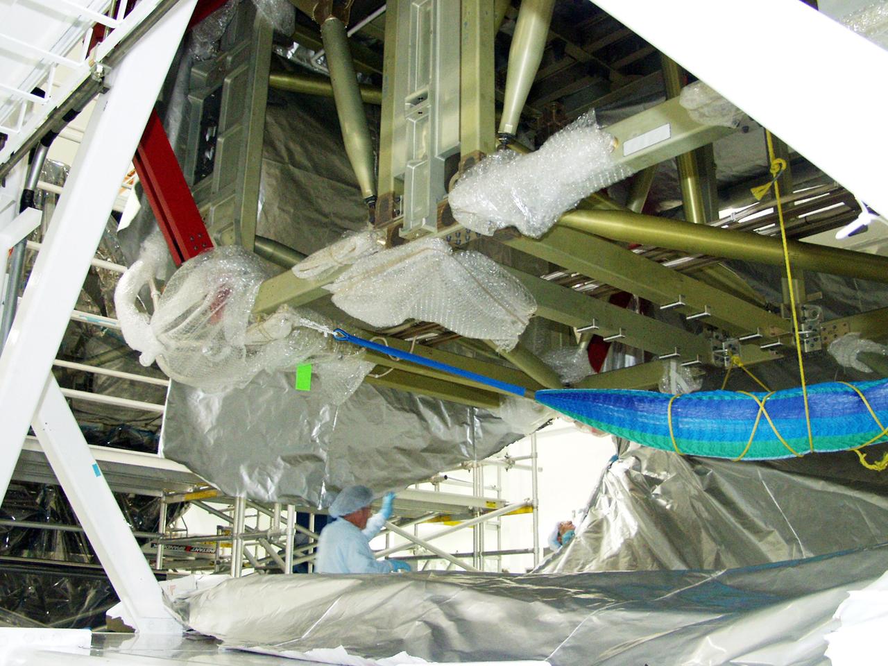 KENNEDY SPACE CENTER, FLA. -- In the Space Station Processing Facility, workers begin uncovering the Long Spacer (LS), the second and final piece of the S6 Integrated Truss Segment. Both the LS and the S6 Integrated Equipment Assembly (IEA) will undergo inspections and verifications tests to prepare them for flight to the International Space Station in early 2004. Although separate for now, the two segments will be integrated and fly as one on mission STS-119. Together the two pieces weigh 26,000 pounds and measure 45 feet long. The S6 is the 11th and final piece of the Station's Integrated Truss Structure, which will measure more than 300 feet in all. .