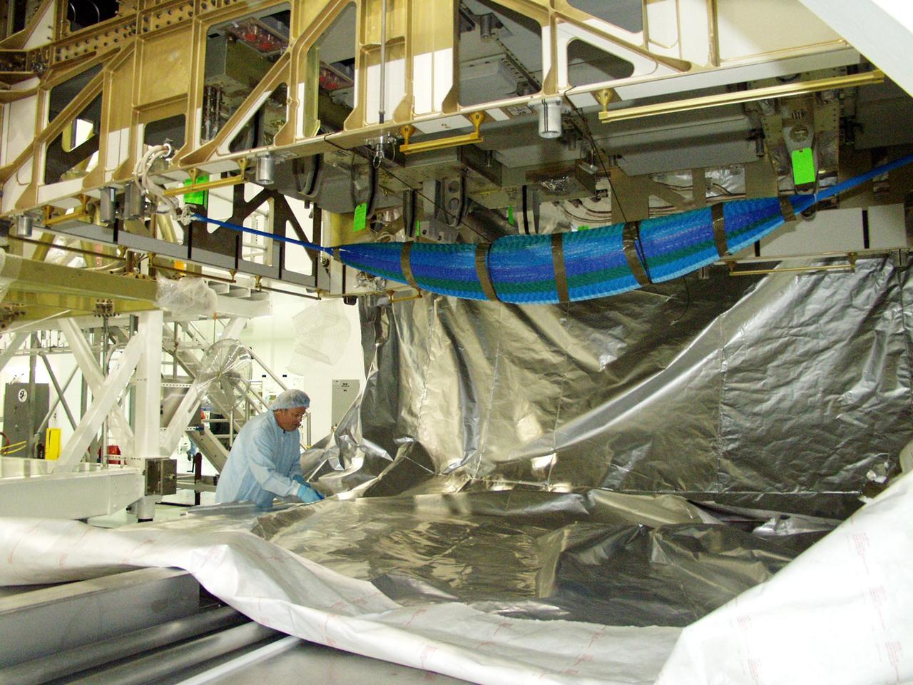 KENNEDY SPACE CENTER, FLA. -- In the Space Station Processing Facility, workers begin uncovering the Long Spacer (LS), the second and final piece of the S6 Integrated Truss Segment. Both the LS and the S6 Integrated Equipment Assembly (IEA) will undergo inspections and verifications tests to prepare them for flight to the International Space Station in early 2004. Although separate for now, the two segments will be integrated and fly as one on mission STS-119. Together the two pieces weigh 26,000 pounds and measure 45 feet long. The S6 is the 11th and final piece of the Station's Integrated Truss Structure, which will measure more than 300 feet in all. .