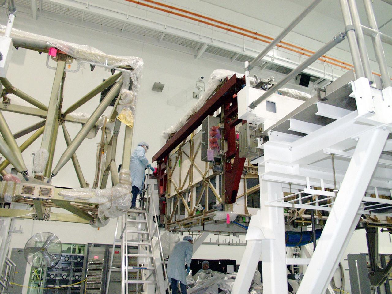 KENNEDY SPACE CENTER, FLA. -- In the Space Station Processing Facility, workers finish uncovering the Long Spacer (LS), the second and final piece of the S6 Integrated Truss Segment. Both the LS and the S6 Integrated Equipment Assembly (IEA) will undergo inspections and verifications tests to prepare them for flight to the International Space Station in early 2004. Although separate for now, the two segments will be integrated and fly as one on mission STS-119. Together the two pieces weigh 26,000 pounds and measure 45 feet long. The S6 is the 11th and final piece of the Station's Integrated Truss Structure, which will measure more than 300 feet in all. .