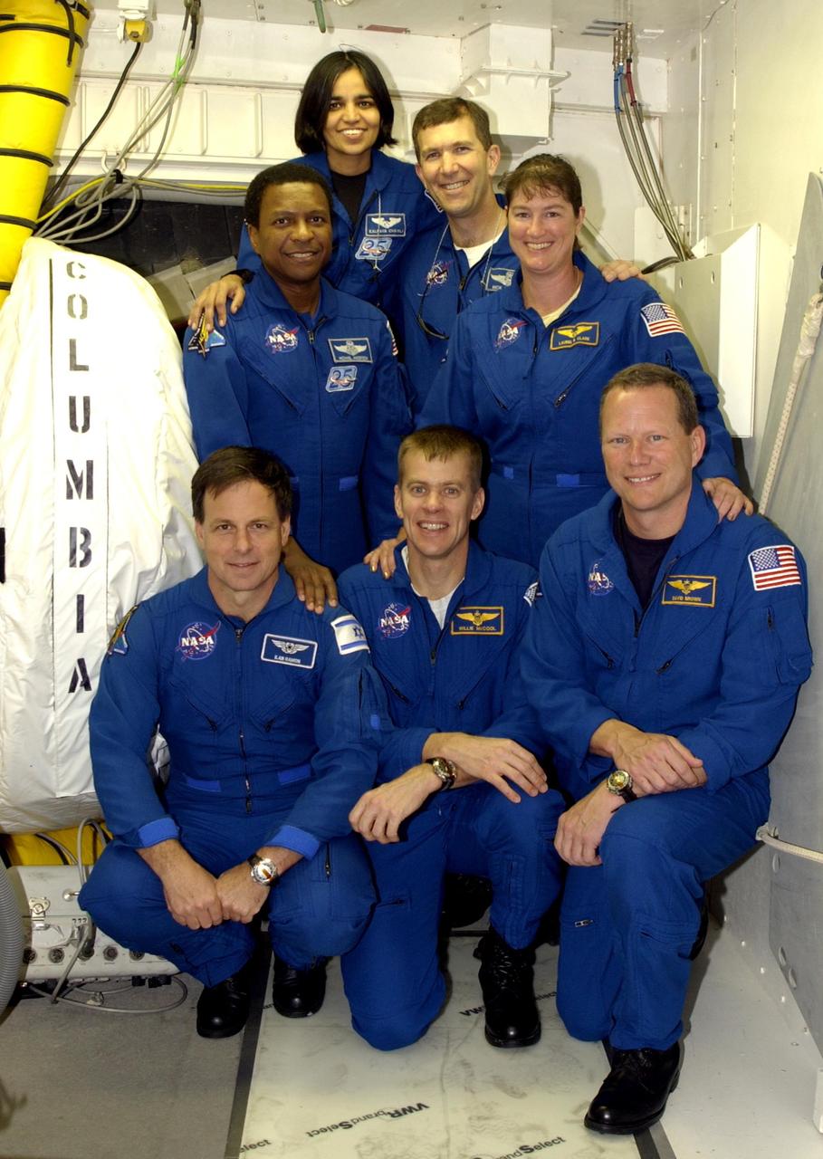 KENNEDY SPACE CENTER, FLA. --  The STS-107 crew poses in front of the entry into Space Shuttle Columbia during Terminal Countdown Demonstration Test activities on the pad.   Kneeling in front are (left to right) Payload Specialist Ilan Ramon (the first Israeli astronaut), Pilot William "Willie" McCool and Mission Specialist David Brown.  Standing in back are (left to right) Payload Commander Michael Anderson, Mission Specialist Kalpana Chawla, Commander Rick Husband and Mission Specialist Laurel Clark. The TCDT also includes a simulated launch countdown.  STS-107 is a mission devoted to research and will include more than 80 experiments that will study Earth and space science, advanced technology development, and astronaut health and safety. Launch is planned for Jan. 16, 2003, between 10 a.m. and 2 p.m. EST aboard Columbia.    .  