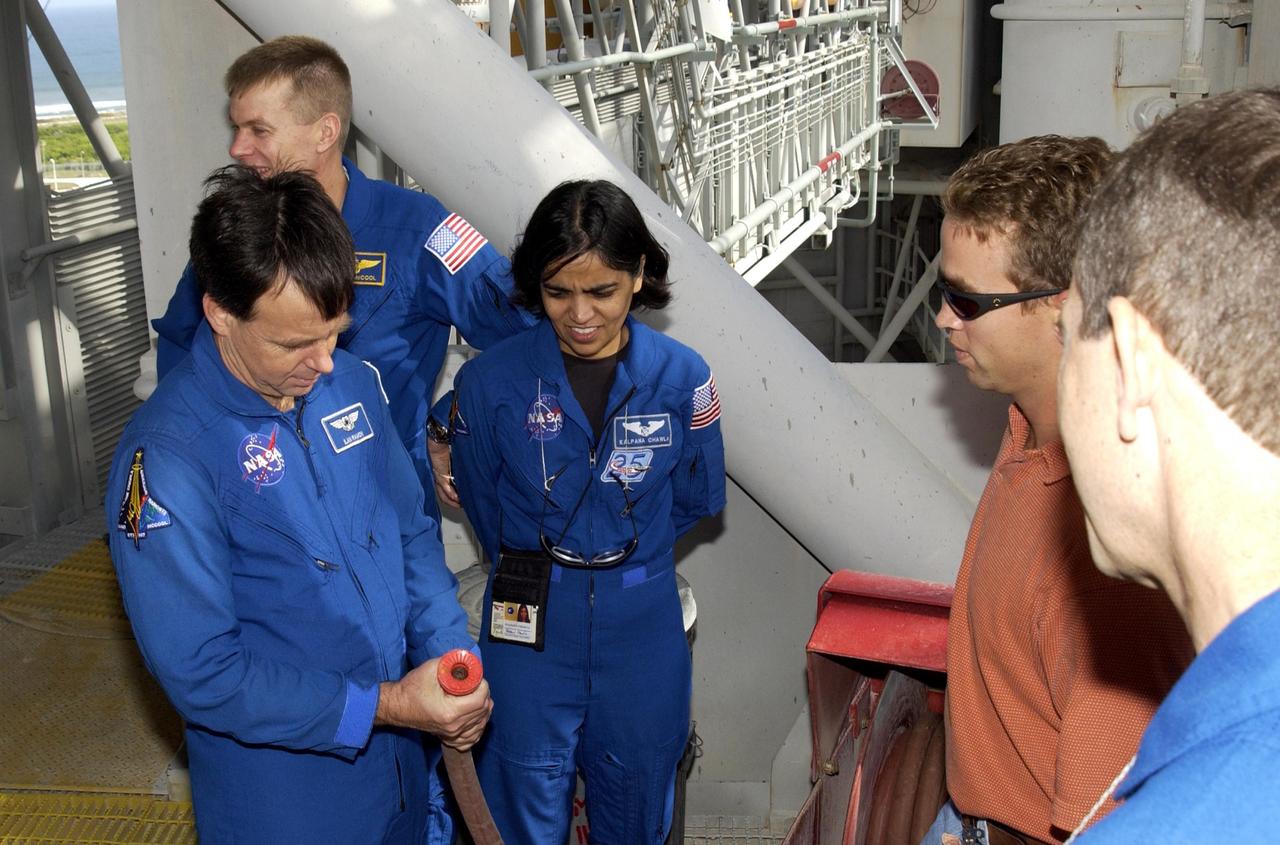 KENNEDY SPACE CENTER, FLA. - During Terminal Countdown Demonstration Test activities on Launch Pad 39A, members of the STS-107 crew check emergency equipment.  From left are Payload Specialist Ilan Ramon (the first Israeli astronaut), Pilot William "Willie" McCool and Mission Specialist Kalpana Chawla. The TCDT also includes a simulated launch countdown. STS-107 is a mission devoted to research and will include more than 80 experiments that will study Earth and space science, advanced technology development, and astronaut health and safety. Launch is planned for Jan. 16, 2003, between 10 a.m. and 2 p.m. EST aboard Space Shuttle Columbia.    .  