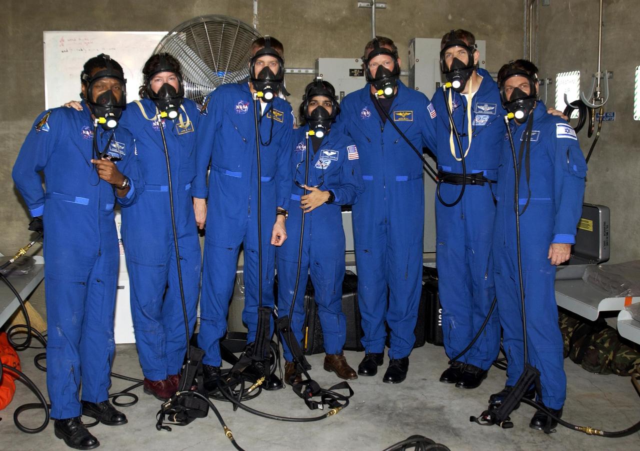KENNEDY SPACE CENTER, FLA. -- During emergency egress training, part of Terminal Countdown Demonstration Test activities at the pad, STS-107 crew members test breathing masks in the emergency bunker.  From left are Payload Commander Michael Anderson, Mission Specialist Laurel Clark, Pilot William "Willie" McCool, Mission Specialists Kalpana Chawla and David Brown, Commander Rick Husband and Mission Specialist Ilan Ramon (the first Israeli astronaut). STS-107 is a mission devoted to research and will include more than 80 experiments that will study Earth and space science, advanced technology development, and astronaut health and safety. Launch is planned for Jan. 16, 2003, between 10 a.m. and 2 p.m. EST aboard Space Shuttle Columbia.    .  