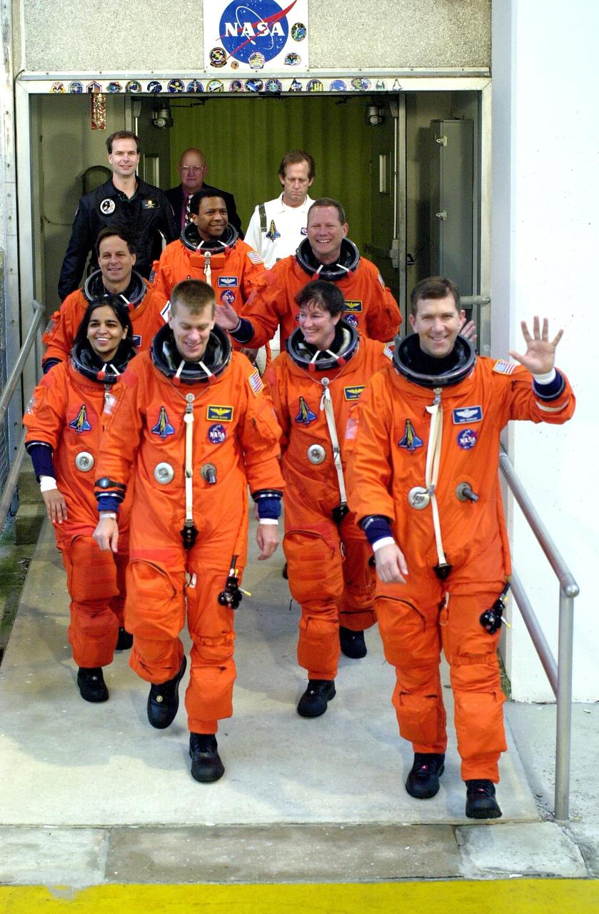 KENNEDY SPACE CENTER, FLA. -- The STS-107 crew exits the Operations and Checkout Building for a ride to Launch Pad 39A and a simulated launch countdown.  From left are Payload Specialist Ilan Ramon, Mission Specialist Kalpana Chawla, Payload Commander Michael Anderson, Mission Specialist David Brown, Pilot William "Willie" McCool, Mission Specialist Laurel Clark and Commander Rick Husband.  The countdown is part of Terminal Countdown Demonstration Test activities. STS-107 is a mission devoted to research and will include more than 80 experiments that will study Earth and space science, advanced technology development, and astronaut health and safety. Launch is planned for Jan. 16, 2003, between 10 a.m. and 2 p.m. EST aboard Space Shuttle Columbia.    .  