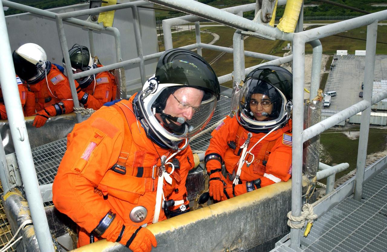 KENNEDY SPACE CENTER, FLA.  - The STS-107 crew practice emergency egress from the launch pad during a simulated launch countdown, part of Terminal Countdown Demonstration Test activities.  In the slidewire basket in the foreground are Mission Specialists David Brown and Kalpana Chawla. STS-107 is a mission devoted to research and will include more than 80 experiments that will study Earth and space science, advanced technology development, and astronaut health and safety. Launch is planned for Jan. 16, 2003, between 10 a.m. and 2 p.m. EST aboard Space Shuttle Columbia.        .  