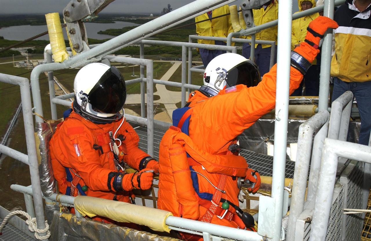 KENNEDY SPACE CENTER, FLA. - Members of the STS-107 crew practice emergency egress from the launch pad, reaching for the release lever of the slidewire basket they are in.  The crew is taking part in a simulated launch countdown, part of Terminal Countdown Demonstration Test activities.   STS-107 is a mission devoted to research and will include more than 80 experiments that will study Earth and space science, advanced technology development, and astronaut health and safety. Launch is planned for Jan. 16, 2003, between 10 a.m. and 2 p.m. EST aboard Space Shuttle Columbia.        .  