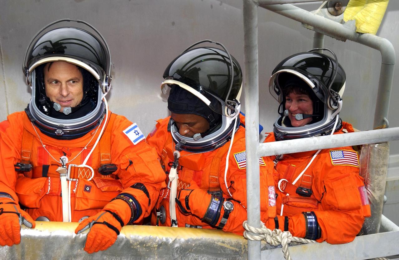 KENNEDY SPACE CENTER, FLA. - Sitting in the slidewire basket on the launch pad are (left to right) STS-107 Payload Specialist Ilan Ramon, Payload Commander Michael Anderson and Mission Specialist Laurel Clark.  The crew is taking part in a simulated launch countdown, part of Terminal Countdown Demonstration Test activities.   STS-107 is a mission devoted to research and will include more than 80 experiments that will study Earth and space science, advanced technology development, and astronaut health and safety. Launch is planned for Jan. 16, 2003, between 10 a.m. and 2 p.m. EST aboard Space Shuttle Columbia.        .  