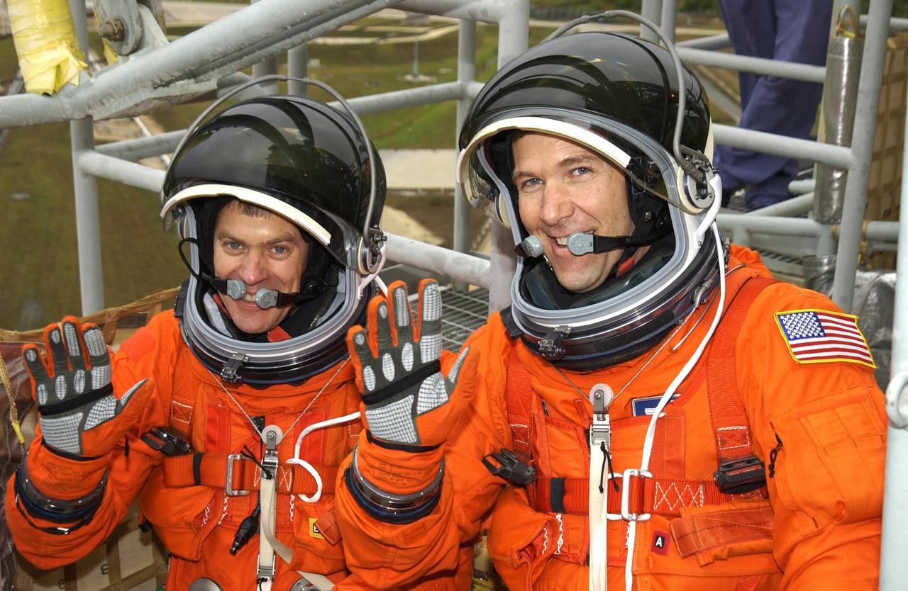 KENNEDY SPACE CENTER, FLA. - Waving from the slidewire basket on the launch pad are (left to right) STS-107 Pilot William "Willie" McCool and Commander Rick Husband. The crew is taking part in a simulated launch countdown, part of Terminal Countdown Demonstration Test activities.   STS-107 is a mission devoted to research and will include more than 80 experiments that will study Earth and space science, advanced technology development, and astronaut health and safety. Launch is planned for Jan. 16, 2003, between 10 a.m. and 2 p.m. EST aboard Space Shuttle Columbia.        .  