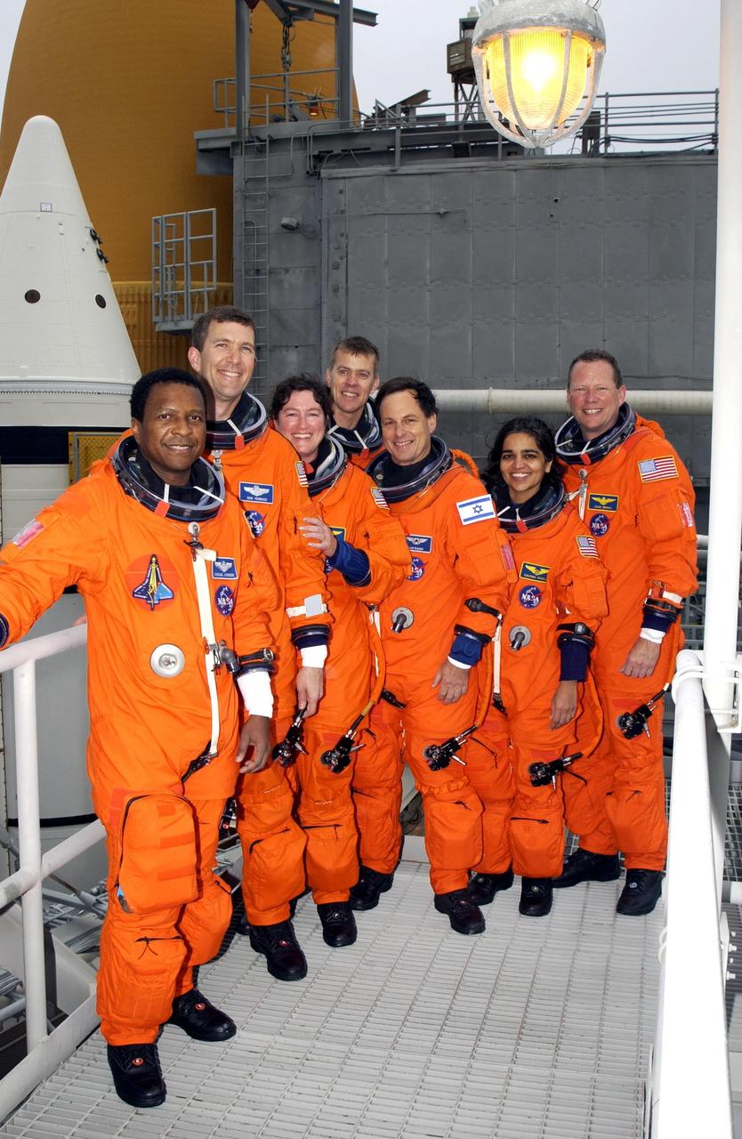 KENNEDY SPACE CENTER, FLA. - During Terminal Countdown Demonstration Test activities at the launch pad, the STS-107 crew pauses for a group photo.  From left are Payload Commander Michael Anderson, Commander Rick Husband, Mission Specialist Laurel Clark, Pilot William "Willie" McCool, and Mission Specialists Ilan Ramon, Kalpana Chawla and David Brown. Behind them is Space Shuttle Columbia.  STS-107 is a mission devoted to research and will include more than 80 experiments that will study Earth and space science, advanced technology development, and astronaut health and safety. Launch is planned for Jan. 16, 2003, between 10 a.m. and 2 p.m. EST aboard Space Shuttle Columbia.        .  