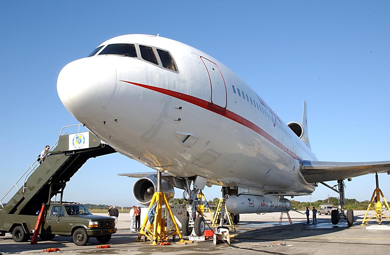 KENNEDY SPACE CENTER, FLA. -- Workers prepare to remove a Pegasus XL Expendable Launch Vehicle from the underside of an Orbital Sciences L-1011 aircraft. The aircraft, with the launch vehicle attached, arrived at the Cape Canaveral Air Force Station Skid Strip on Dec. 17. The Pegasus XL will undergo three flight simulations prior to its scheduled launch in late January 2003. It will carry NASA's Solar Radiation and Climate Experiment (SORCE) spacecraft into orbit. Built by Orbital Sciences Space Systems Group, SORCE will study and measure solar irradiance as a source of energy in the Earth's atmosphere with instruments built by the University of Colorado's Laboratory for Atmospheric and Space Physics (LASP).