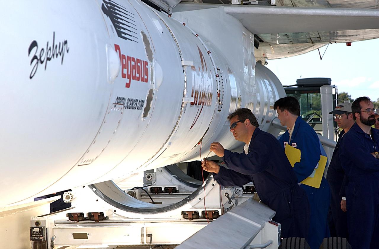 KENNEDY SPACE CENTER, FLA. -- Workers complete the final steps to detach a Pegasus XL Expendable Launch Vehicle from the underside of an Orbital Sciences L-1011 aircraft. The aircraft, with the launch vehicle nestled beneath, arrived at the Cape Canaveral Air Force Station Skid Strip on Dec. 17. The Pegasus XL will undergo three flight simulations prior to its scheduled launch in late January 2003. It will carry NASA's Solar Radiation and Climate Experiment (SORCE) spacecraft into orbit. Built by Orbital Sciences Space Systems Group, SORCE will study and measure solar irradiance as a source of energy in the Earth's atmosphere with instruments built by the University of Colorado's Laboratory for Atmospheric and Space Physics (LASP).