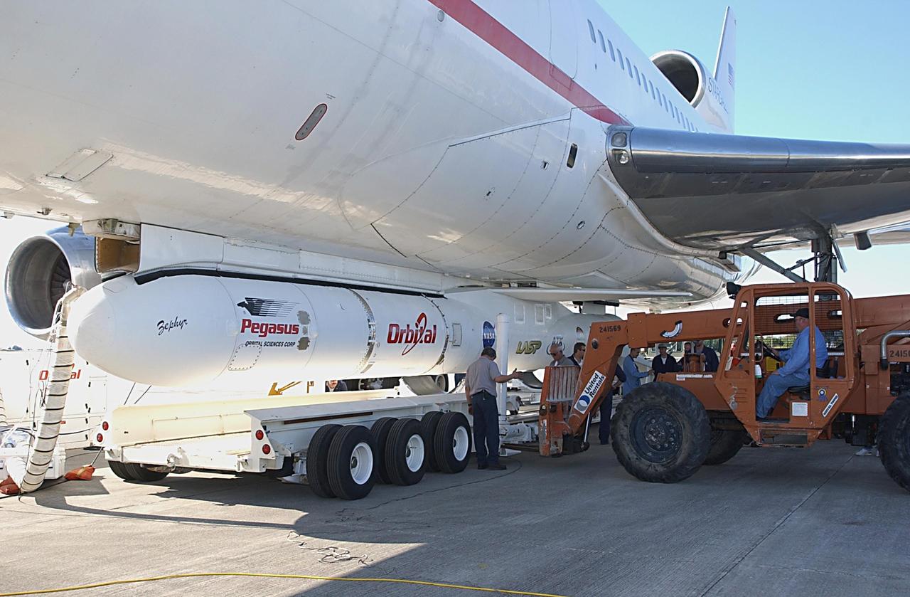 KENNEDY SPACE CENTER, FLA. -- Workers complete the process to detach a Pegasus XL Expendable Launch Vehicle from the underside of an Orbital Sciences L-1011 aircraft and lower it onto a transporter. The aircraft, with the launch vehicle nestled beneath, arrived at the Cape Canaveral Air Force Station Skid Strip on Dec. 17. The Pegasus XL will undergo three flight simulations prior to its scheduled launch in late January 2003. It will carry NASA's Solar Radiation and Climate Experiment (SORCE) spacecraft into orbit. Built by Orbital Sciences Space Systems Group, SORCE will study and measure solar irradiance as a source of energy in the Earth's atmosphere with instruments built by the University of Colorado's Laboratory for Atmospheric and Space Physics (LASP).