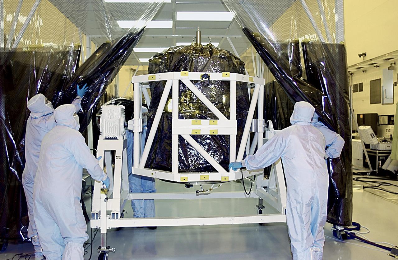 KENNEDY SPACE CENTER, FLA. - Workers move the SORCE satellite back under the protective canopy for mating to the Pegasus launch vehicle. The satellite will be rotated before the mating to Pegasus. SORCE is equipped with four instruments that will measure variations in solar radiation and observe some spectral properties of solar radiation for the first time. With data from NASA's SORCE mission, researchers should be able to follow how the Sun affects our climate now and in the future. Launch of SORCE aboard the Pegasus XL rocket is scheduled for Jan. 25, 2003, at approximately 3:14 p.m. EST, from Cape Canaveral Air Force Station, Fla.