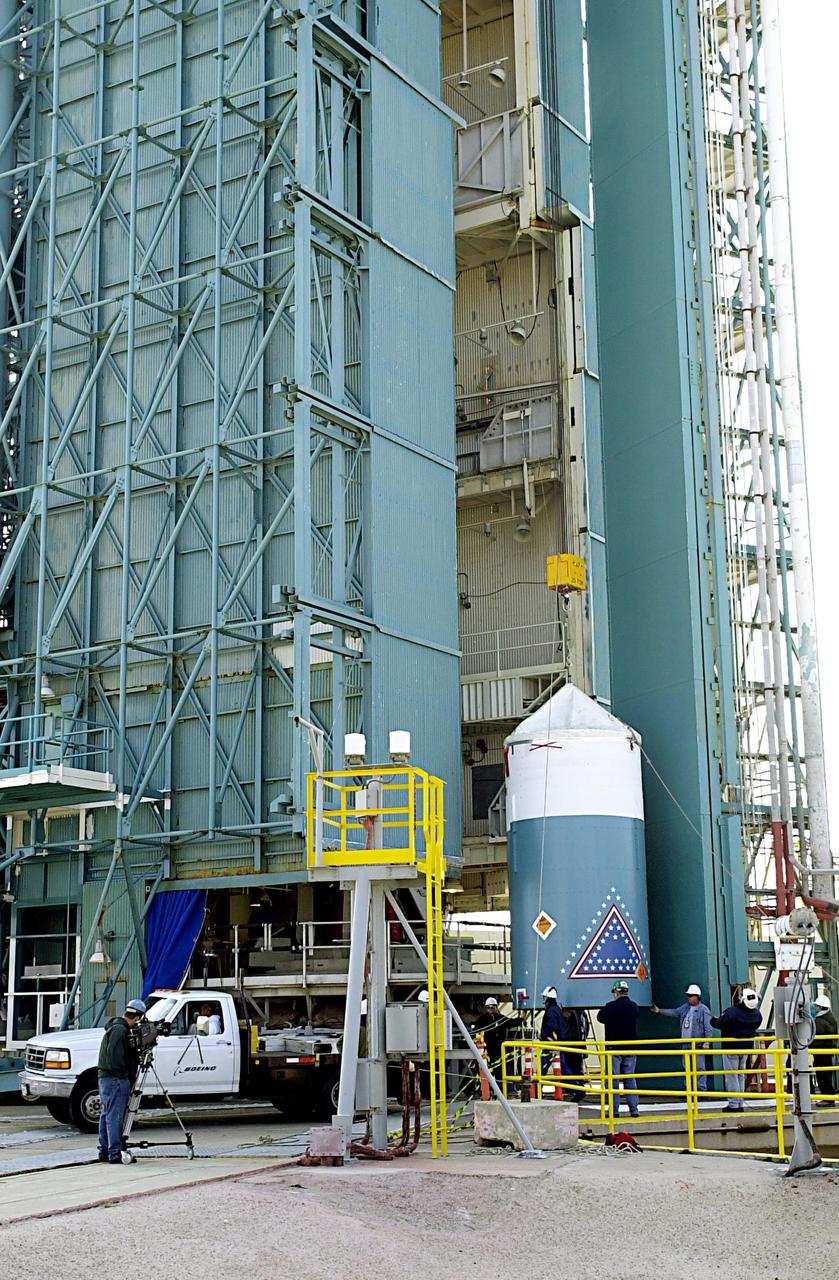 KENNEDY SPACE CENTER, FLA. - Workers at the base of the launch tower on NASA's Space Launch Complex 2 (SLC-2), Vandenberg Air Force Base, Calif., watch as the interstage of the Delta II rocket is lifted up the tower. The interstage will eventually house the second stage and will be mated with the first stage. The rocket will carry the ICESat and CHIPSat satellites into Earth orbits. ICESat is a 661-pound satellite known as Geoscience Laser Altimeter System (GLAS) that will revolutionize our understanding of ice and its role in global climate change and how we protect and understand our home planet. It will help scientists determine if the global sea level is rising or falling. It will look at the ice sheets that blanket the Earth's poles to see if they are growing or shrinking. It will assist in developing an understanding of how changes in the Earth's atmosphere and climate effect polar ice masses and global sea level. CHIPSat, a suitcase-size 131-pound satellite, will provide invaluable information into the origin, physical processes and properties of the hot gas contained in the interstellar medium. This can provide important clues about the formation and evolution of galaxies since the interstellar medium literally contains the seeds of future stars. The Delta II launch is scheduled for Jan. 11 between 4:45 p.m. - 5:30 p.m. PST.