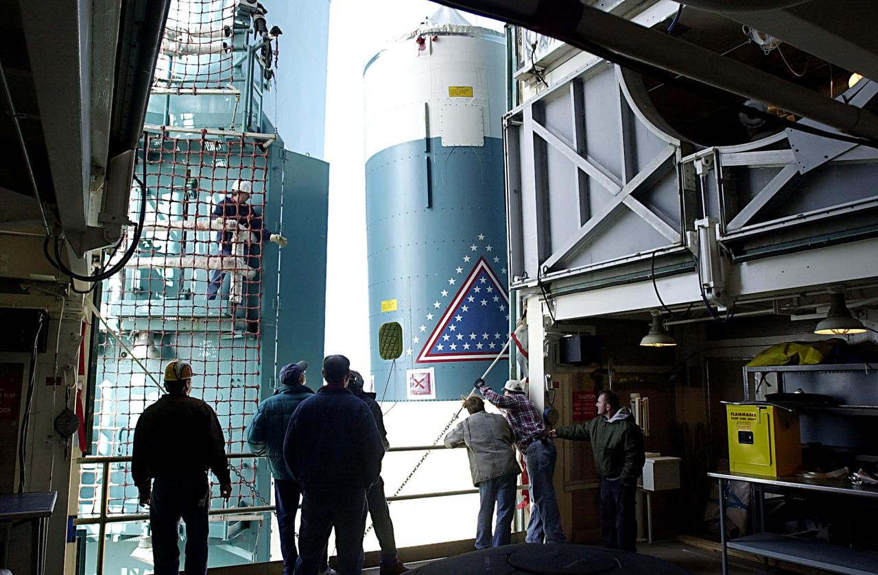 KENNEDY SPACE CENTER, FLA. - Workers on the launch tower on NASA's Space Launch Complex 2 (SLC-2), Vandenberg Air Force Base, Calif., watch as the interstage of the Delta II rocket is lifted to a level where it can be mated with the first stage. The rocket will carry the ICESat and CHIPSat satellites into Earth orbits. ICESat is a 661-pound satellite known as Geoscience Laser Altimeter System (GLAS) that will revolutionize our understanding of ice and its role in global climate change and how we protect and understand our home planet. It will help scientists determine if the global sea level is rising or falling. It will look at the ice sheets that blanket the Earth's poles to see if they are growing or shrinking. It will assist in developing an understanding of how changes in the Earth's atmosphere and climate effect polar ice masses and global sea level. CHIPSat, a suitcase-size 131-pound satellite, will provide invaluable information into the origin, physical processes and properties of the hot gas contained in the interstellar medium. This can provide important clues about the formation and evolution of galaxies since the interstellar medium literally contains the seeds of future stars. The Delta II launch is scheduled for Jan. 11 between 4:45 p.m. - 5:30 p.m. PST.